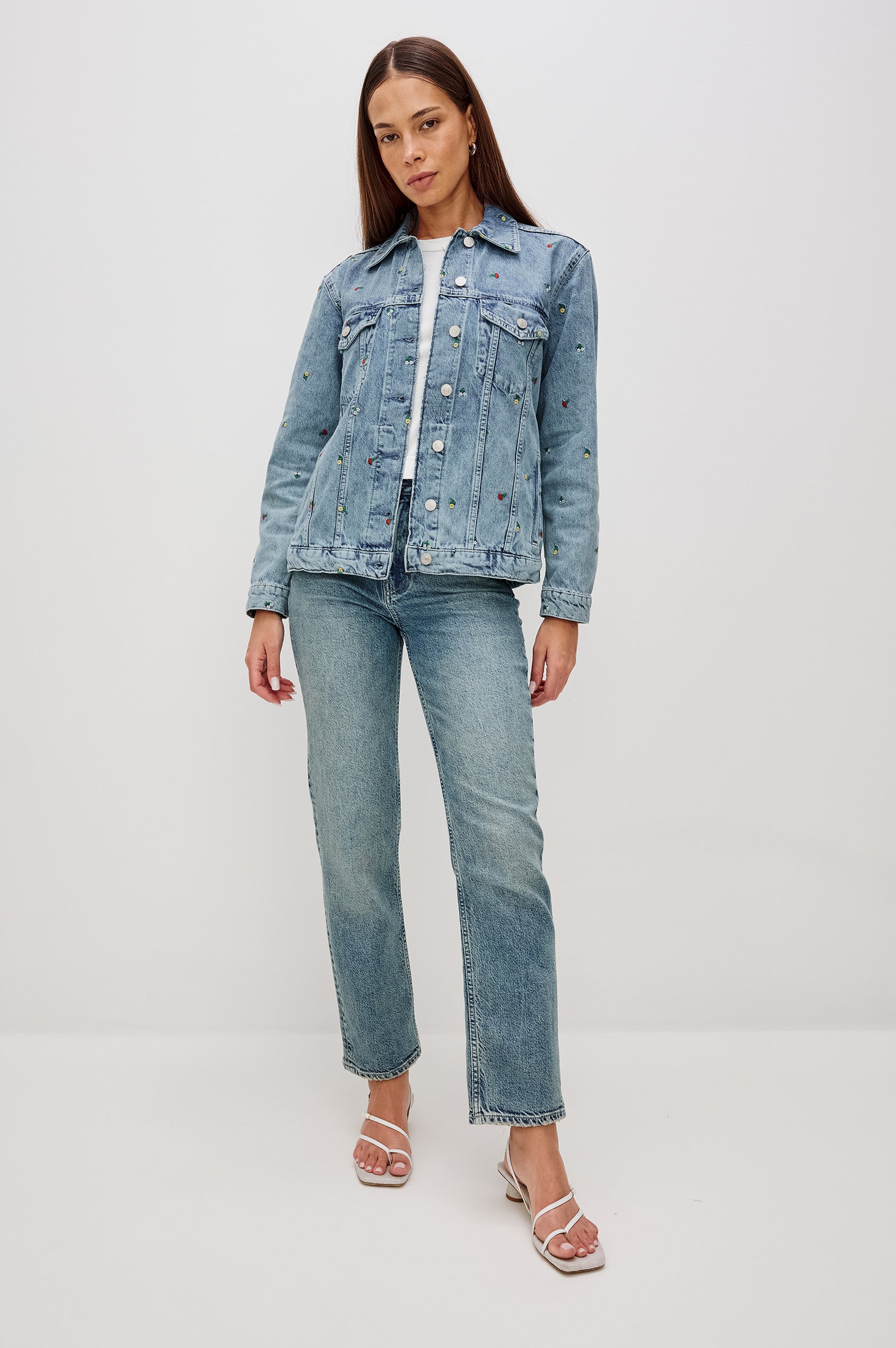 Grove Boyfriend Trucker Denim Jacket with Button Closure, Two Front Pockets, Two Chest Button Flap Pockets, Front Vertical Seams in Flower Field Colorway, with Embroidered Daisies in Yellow, Red and White - Front Full Body View Featured on Model  