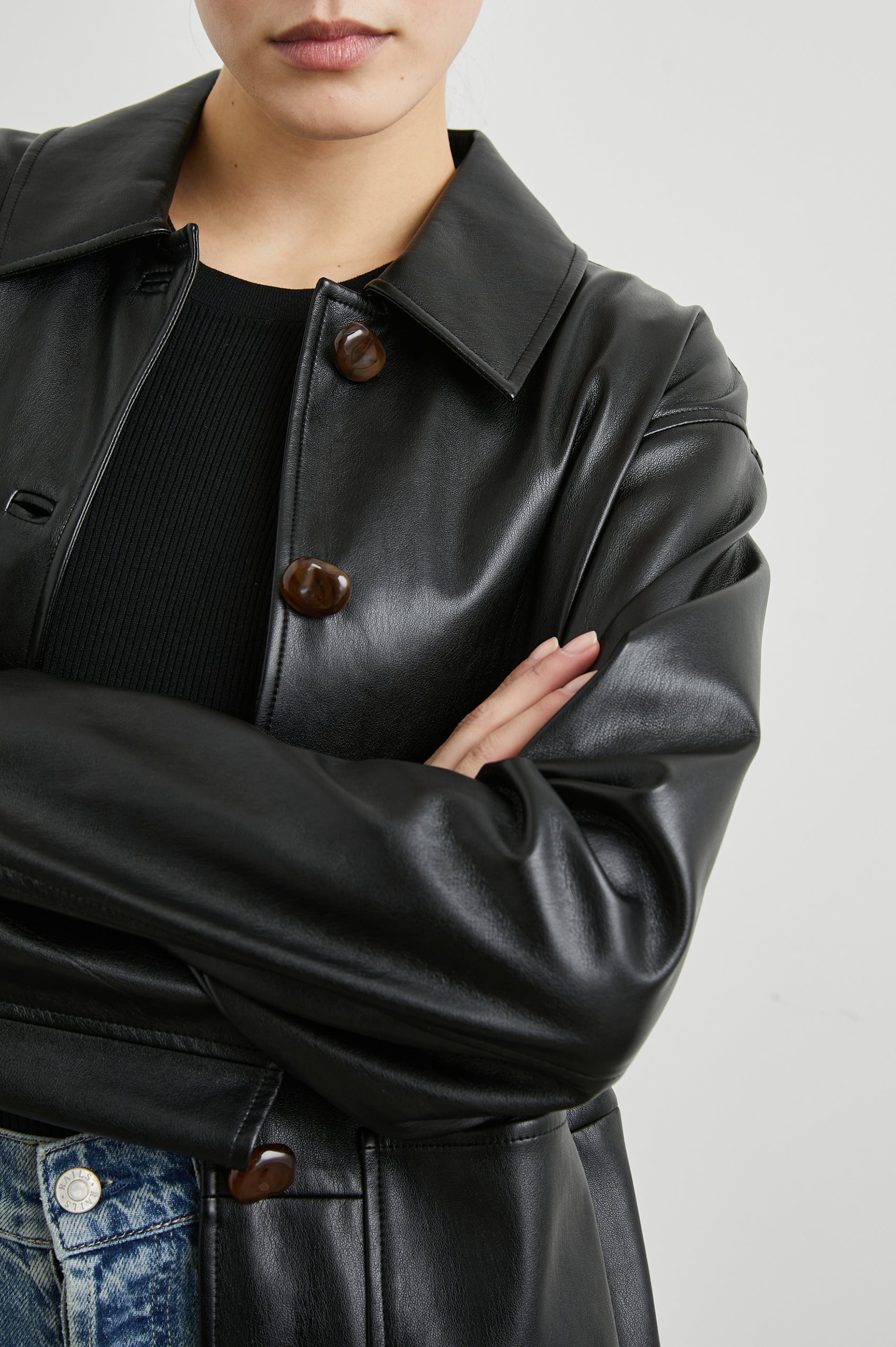 Haisley Faux Leather Jacket with Tortoiseshell Button Closure and Two Front Patch Pockets in Black Colorway - Front View Featured on Model 