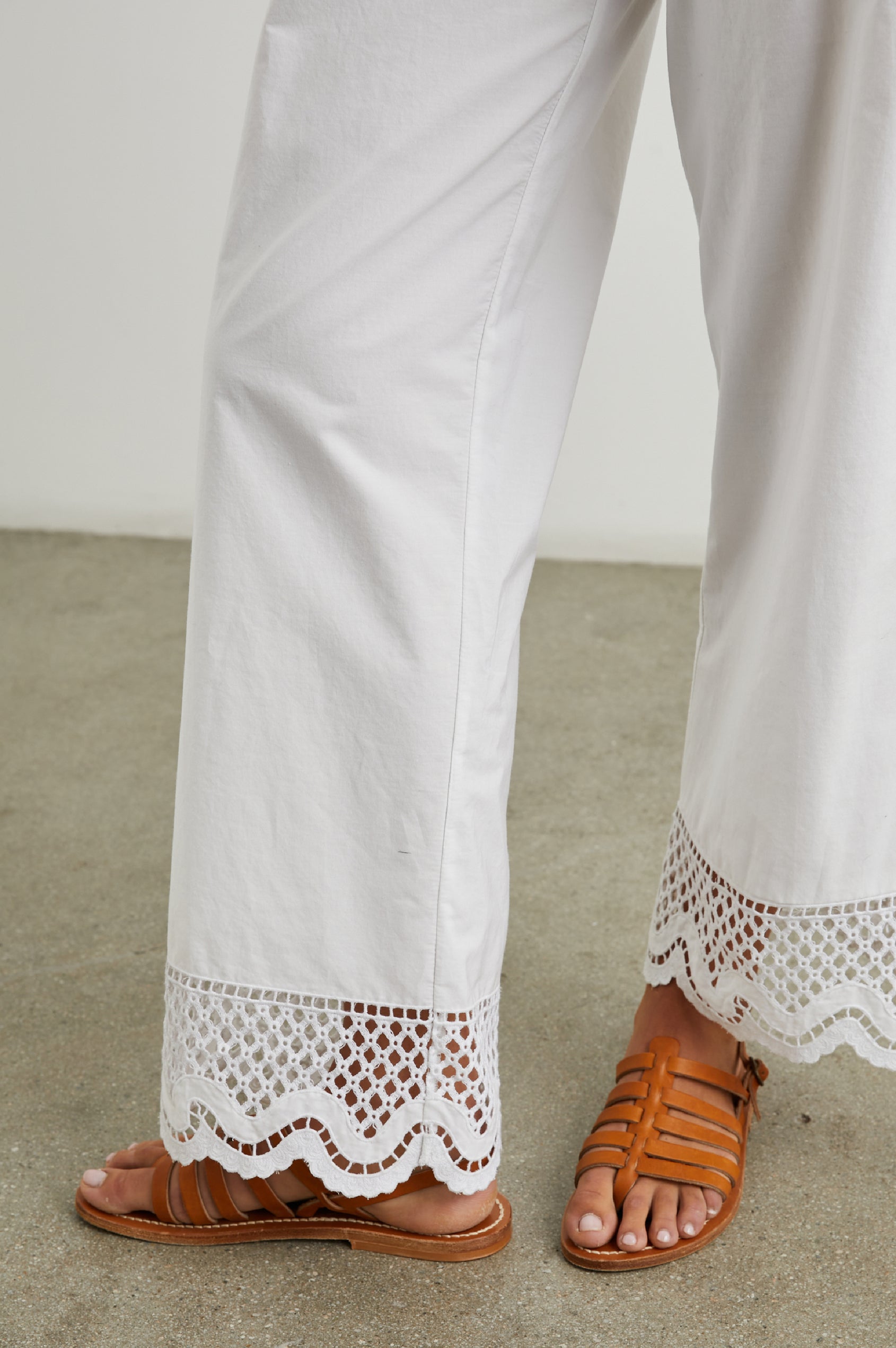 Henrik Pants with a Shirred Waist, Two Front Pockets and an Eyelet Design at the Hems in White Colorway - Front View Featured on Model 