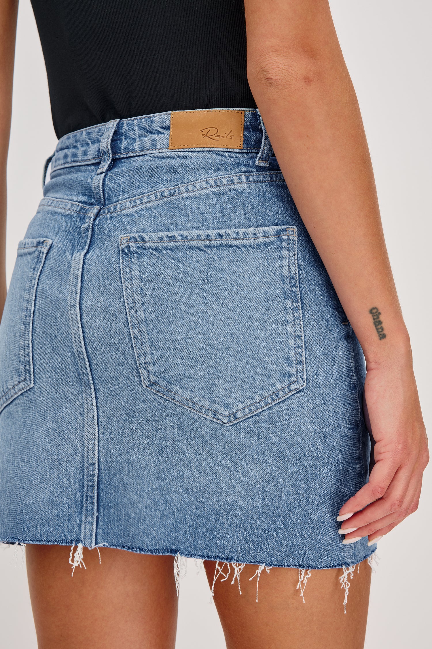 Highland 5-Pocket Denim Mini Skirt with Standard Zip + Button Fly, Raw Hem in Baja Blue Colorway. Back Detail View Shown on Model.