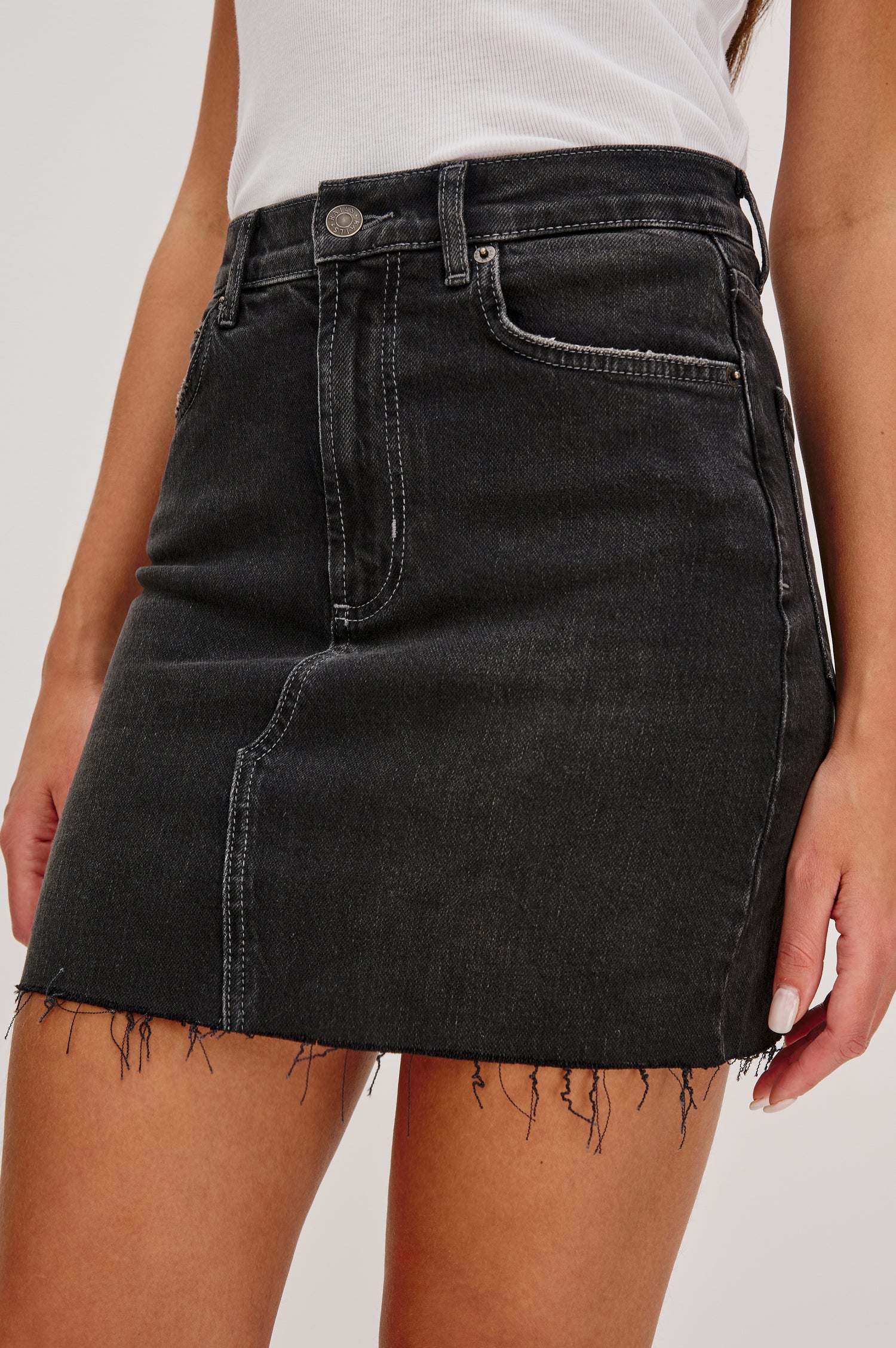 Highland 5-Pocket Denim Mini Skirt with Standard Zip + Button Fly, Raw Hem in Black Spellbound Colorway. Front Detail View Shown on Model.