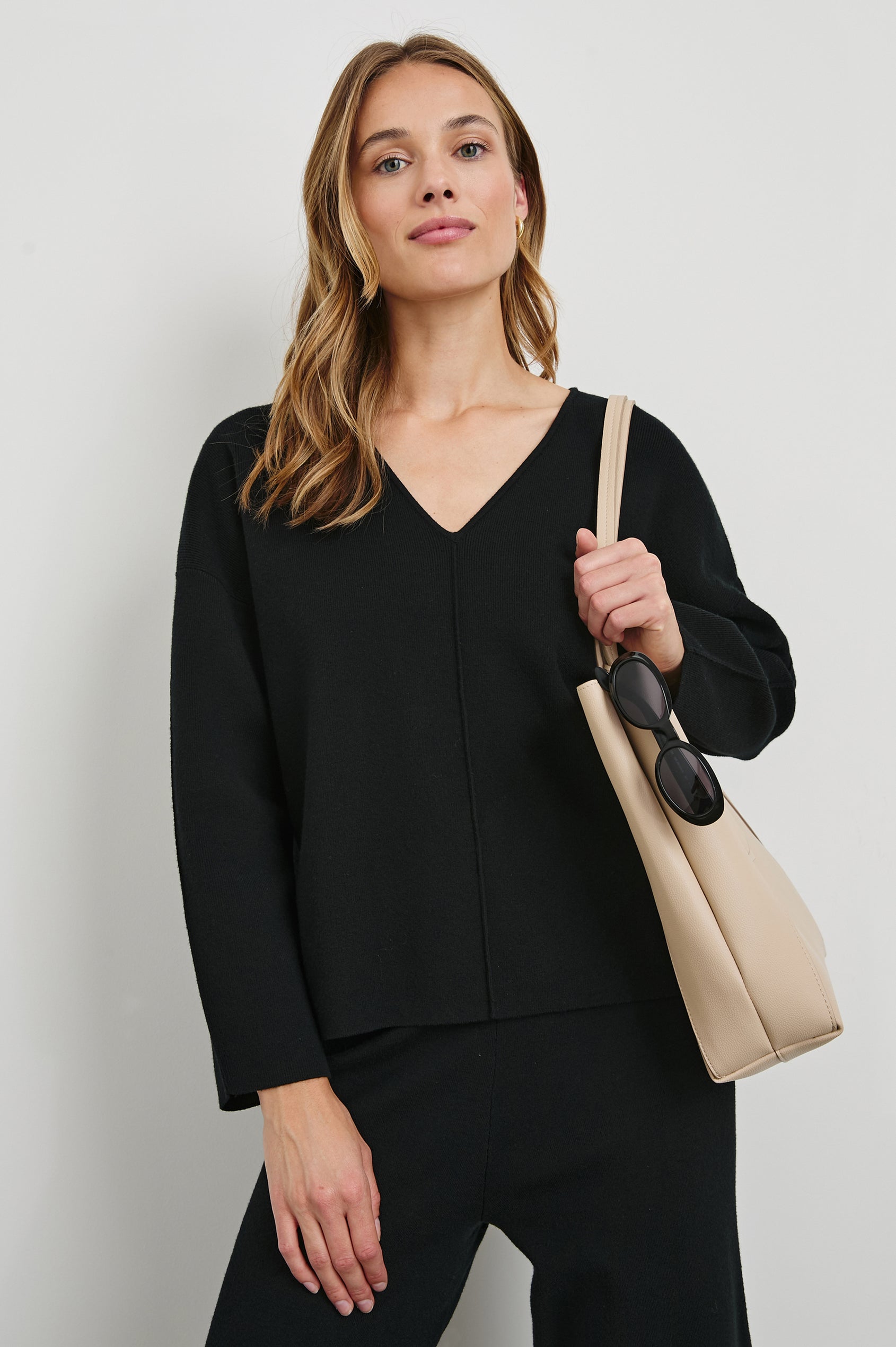 Hollyn Long-Sleeve Sweater with a V Neck and a Seam Down the Front Bodice and Sleeves in Black Colorway- Front View Featured on Model