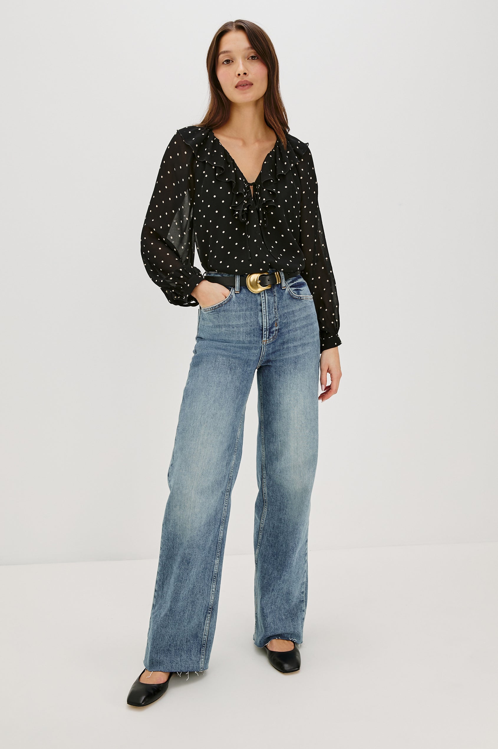 Honora is a lightweight chiffon top with a ruffled neckline and self-tie front closures. The semi-sheer top is partially lined and styled with a soft, feminine silhouette in Polka Dots Colorway - Full Body Front View Featured on Model