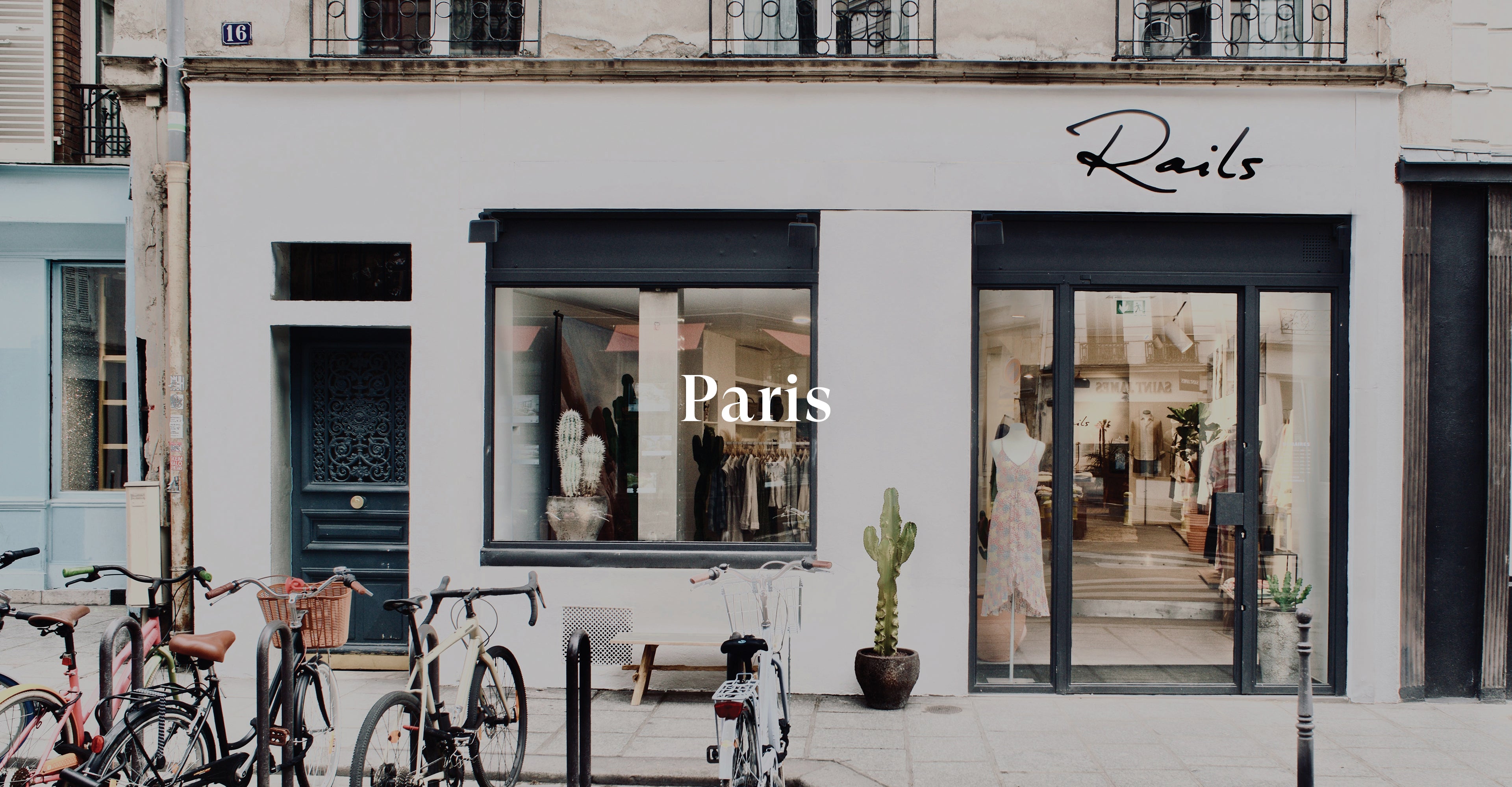 OUTSIDE OF PARIS STORE SHOWING THE FRONT ENTRANCE (LARGE GLASS DOOR) AND LARGE FRONT WINDOW