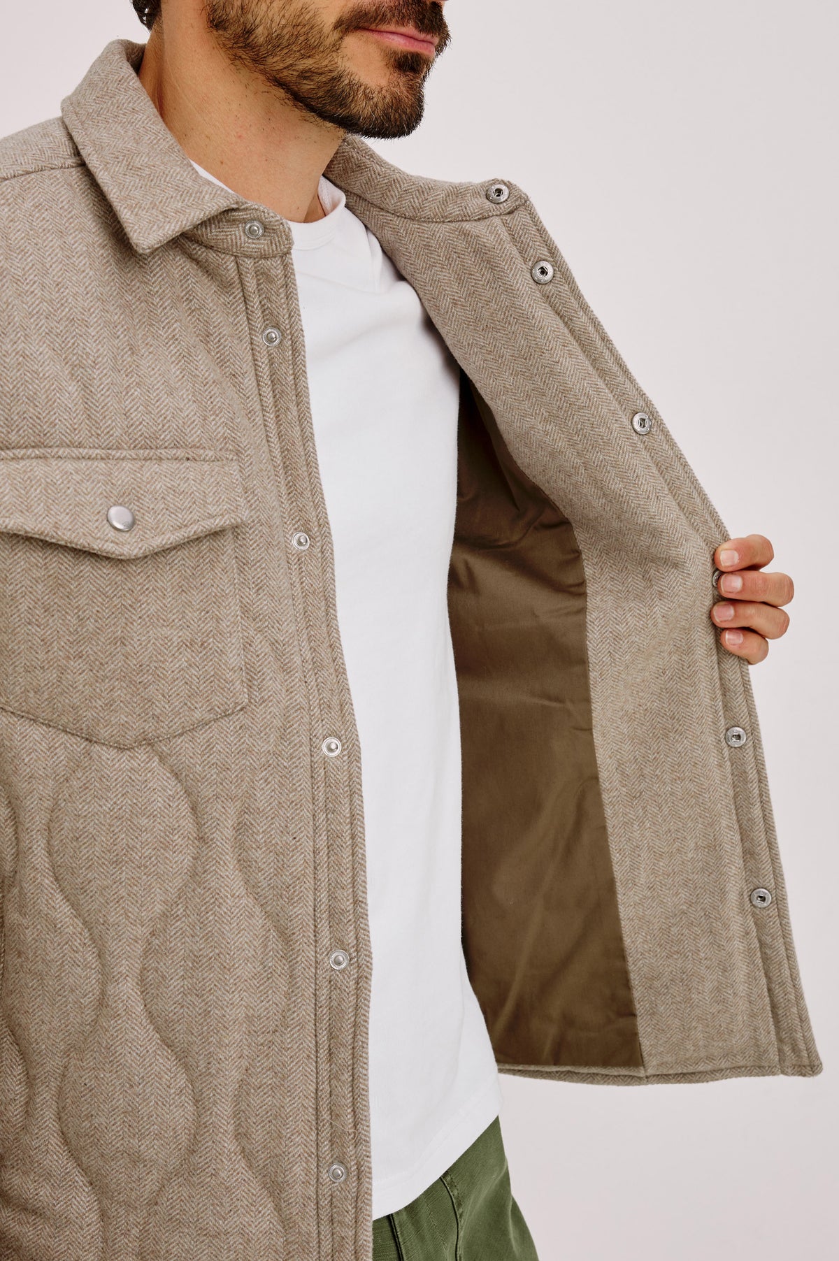 Humboldt Jacket in Wool Blend With Herringbone Texture, Channel Quilting, Filling, Snap Front, Collar, and Chest Flap Pockets in Stonefield Herringbone Colorway - Upper Body Front Detail View Featured on Model.
