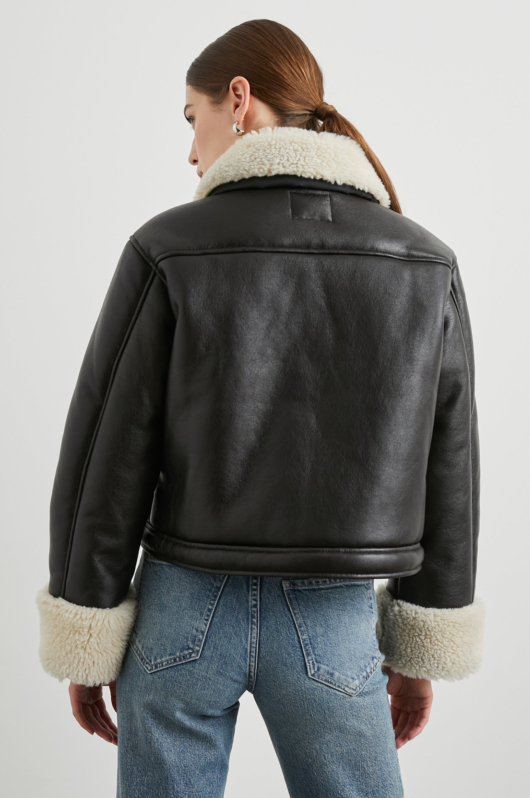 Imani Cropped Faux Leather Jacket with Snap Closure, Two Front Snap Flap Pockets and Ivory Faux Shearling Lining, Collar and Cuffs in Black Ivory Colorway, with Silver-Toned Snaps - Back View Featured on Model  