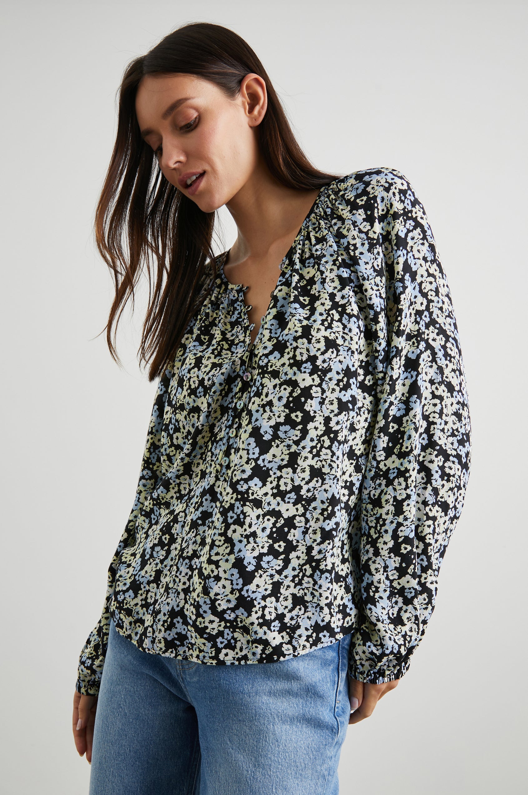 Indi Top with a V Neckline with a Button Placket, Pleating at Back Neckline and Elastic Cuffs in Midnight Meadow Floral Colorway, with cream and blue flowers on  midnight - Front View Featured on Model