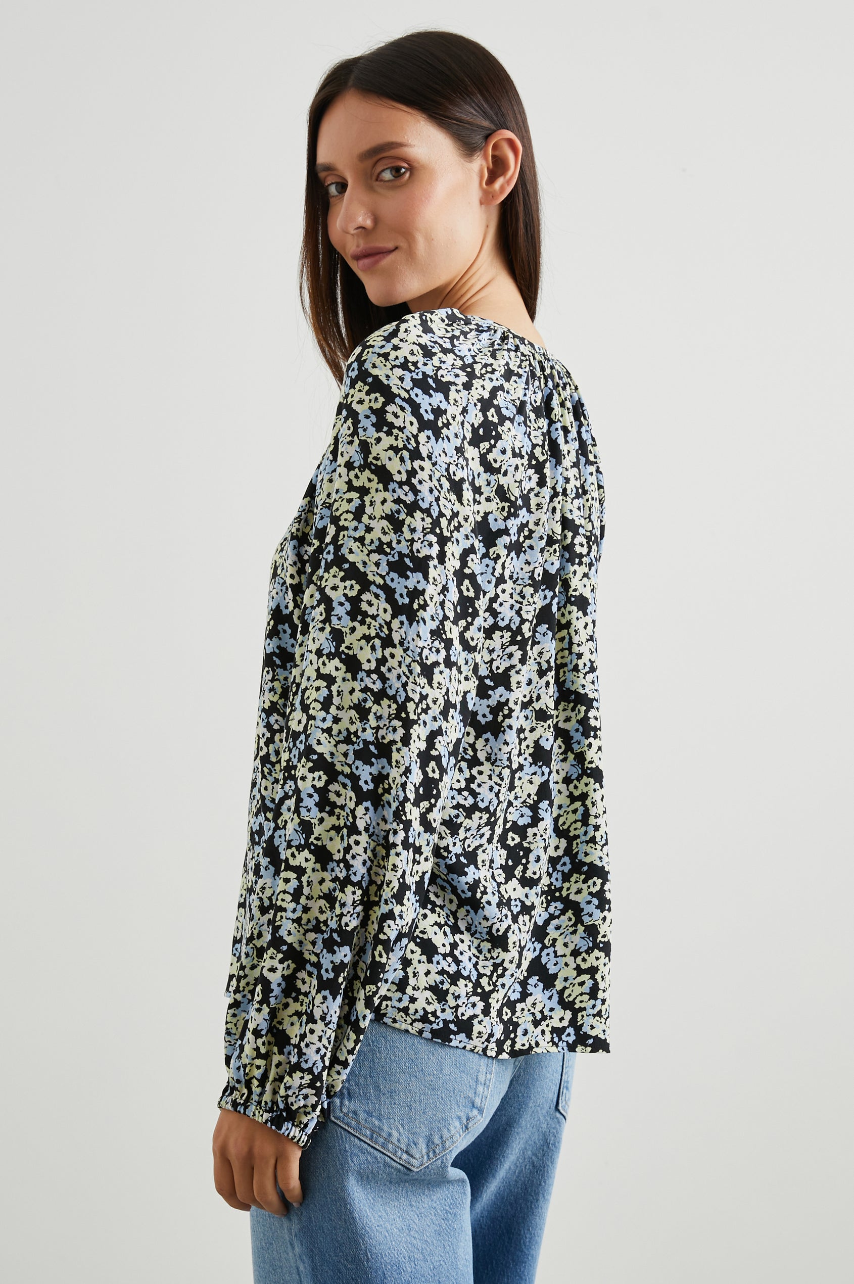Indi Top with a V Neckline with a Button Placket, Pleating at Back Neckline and Elastic Cuffs in Midnight Meadow Floral Colorway, with cream and blue flowers on midnight - Side View Featured on Model