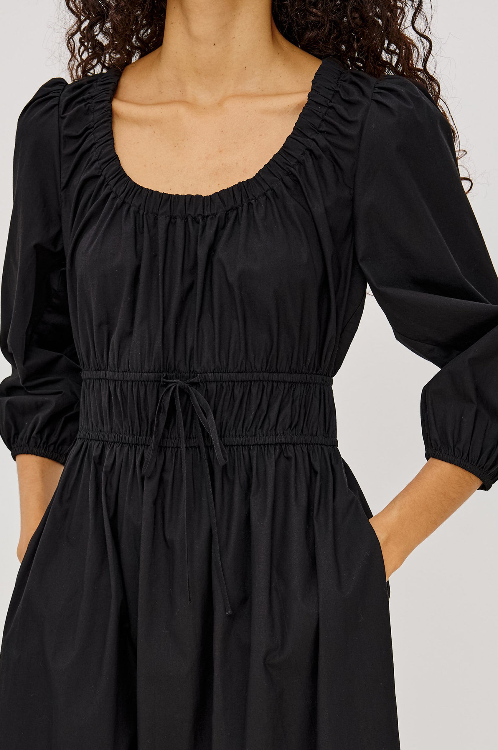 Isabelle Maxi Dress in Cotton Poplin With Ruched Scoop Neck, Puff Elbow-Length Sleeves, and Laddered Shirred Waist With Ties in Black Colorway - Upper Body Front View Featured on Model