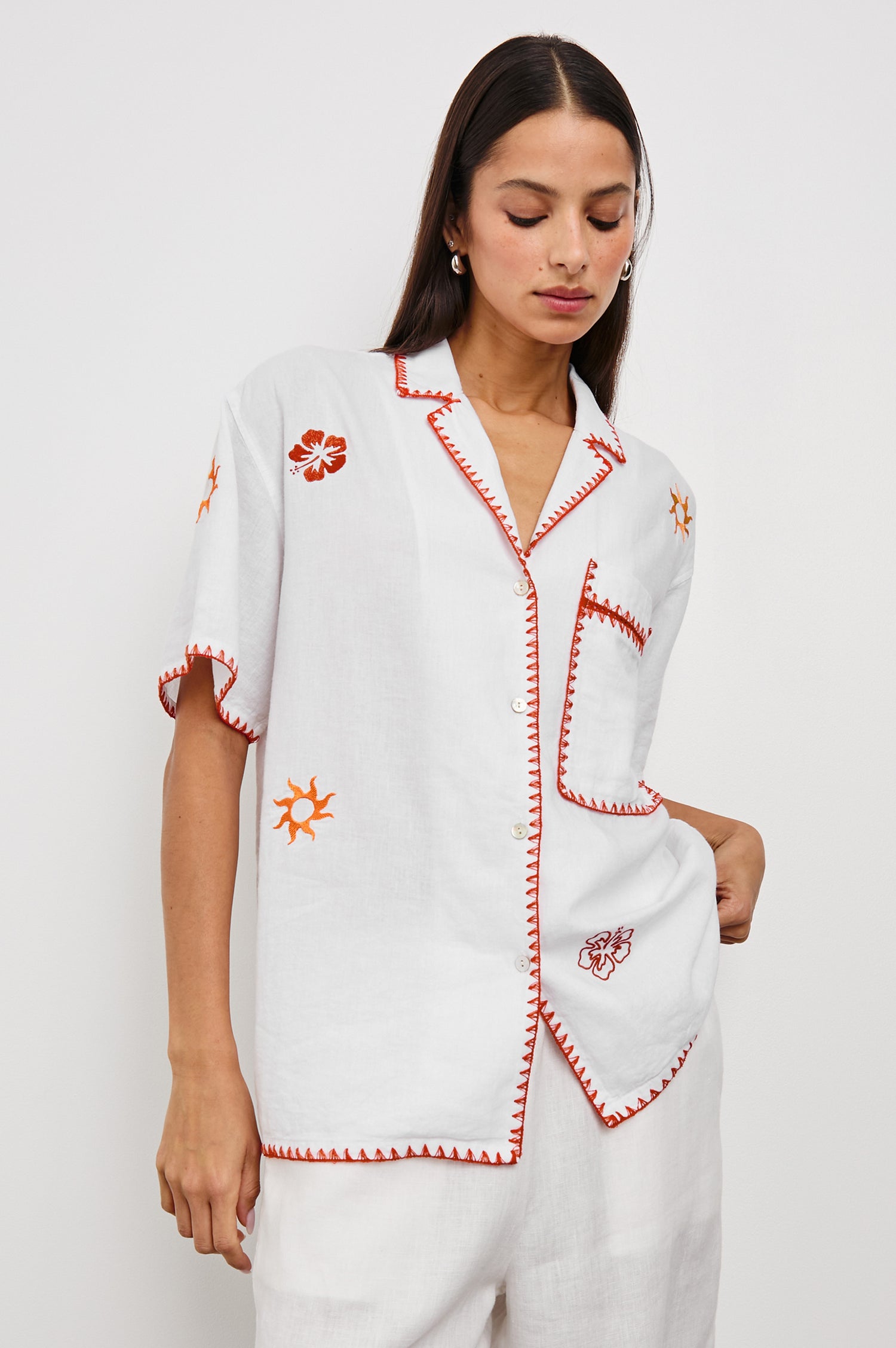 Island Short-Sleeve, Button-Down Shirt with Flat Collar, Large Chest Patch Pocket, Embroidered Decorative Trim and Embroidered Flowers and Sun in Red and Yellows in White Colorway - Front View Featured on Model 