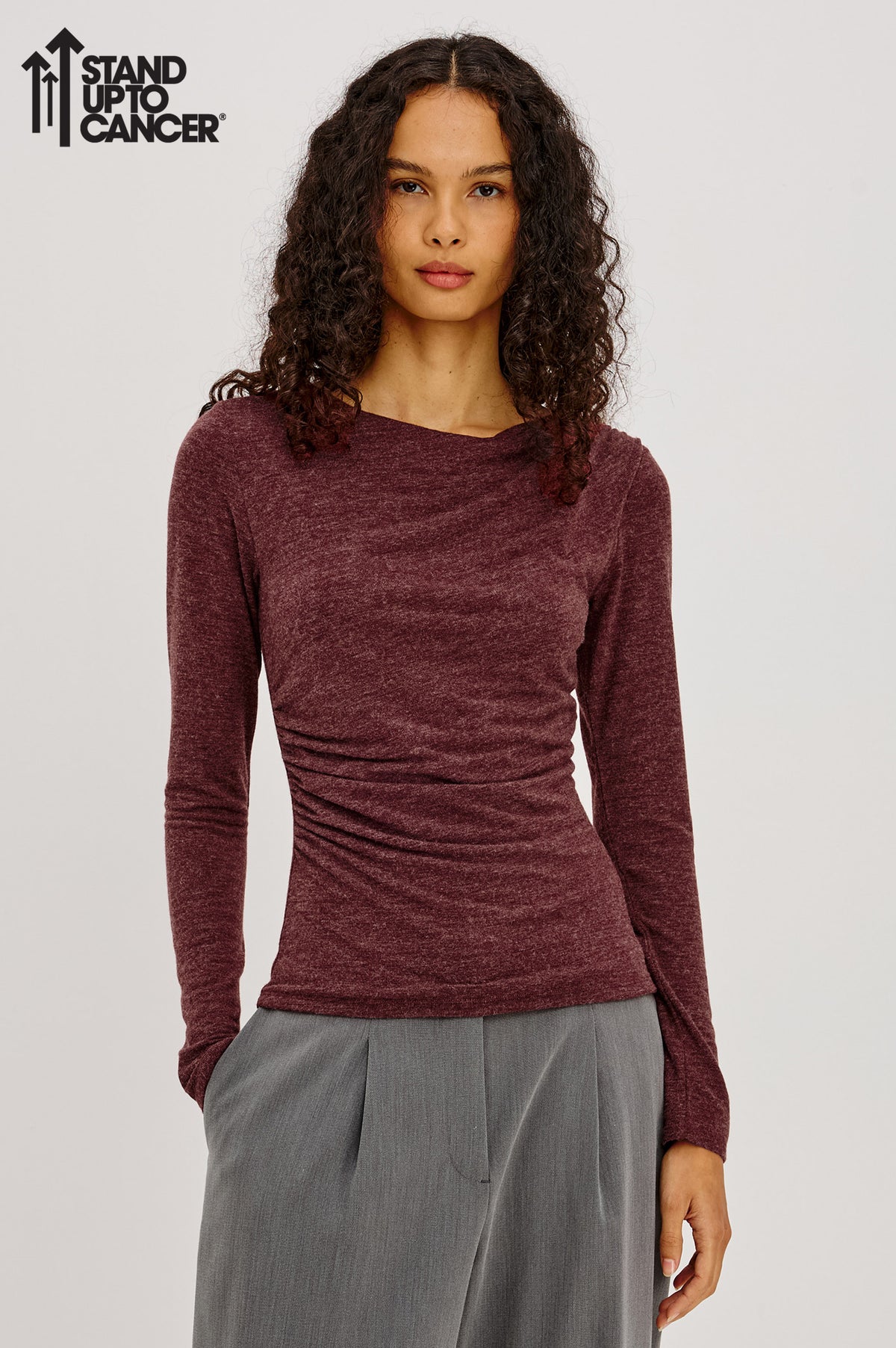Issel Top in Soft Jersey With Cowl Neckline, Ruched Waist, and Form-Fitting Silhouette in Merlot Colorway with Stand Up To Cancer Logo on Image - Upper Body Front View Featured on Model