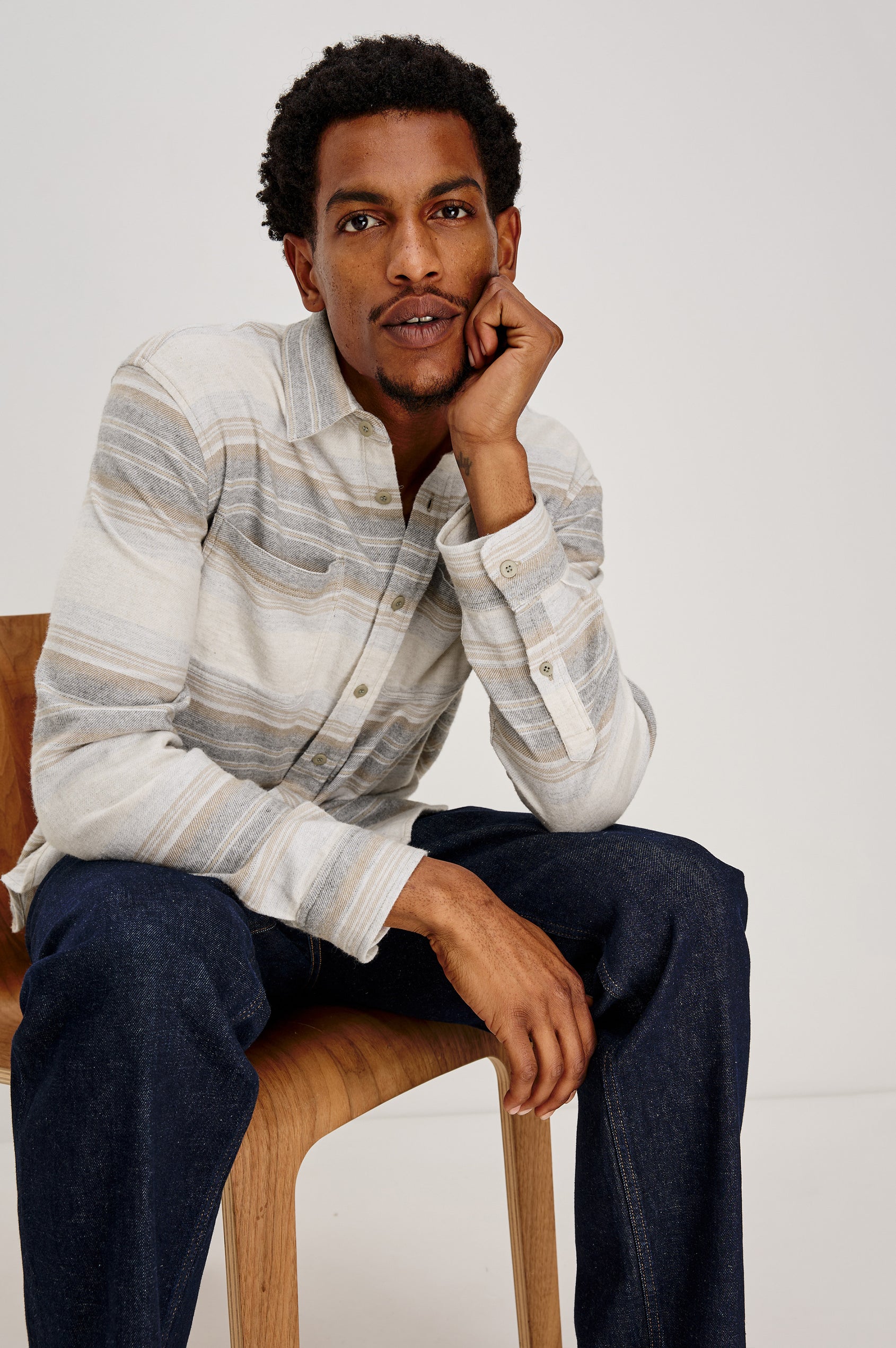 Ivan button front collared shirt with long sleeves and two chest pockets in horizontal stripe - lunar rock stripe colorway. Front View of Model Sitting Shown.