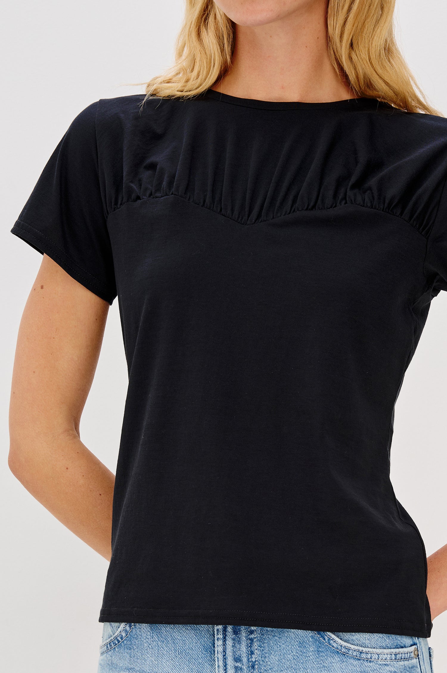 Janis crewneck short sleeve t-shirt with sweetheart neckline hem details in Black colorway - close up of details on model