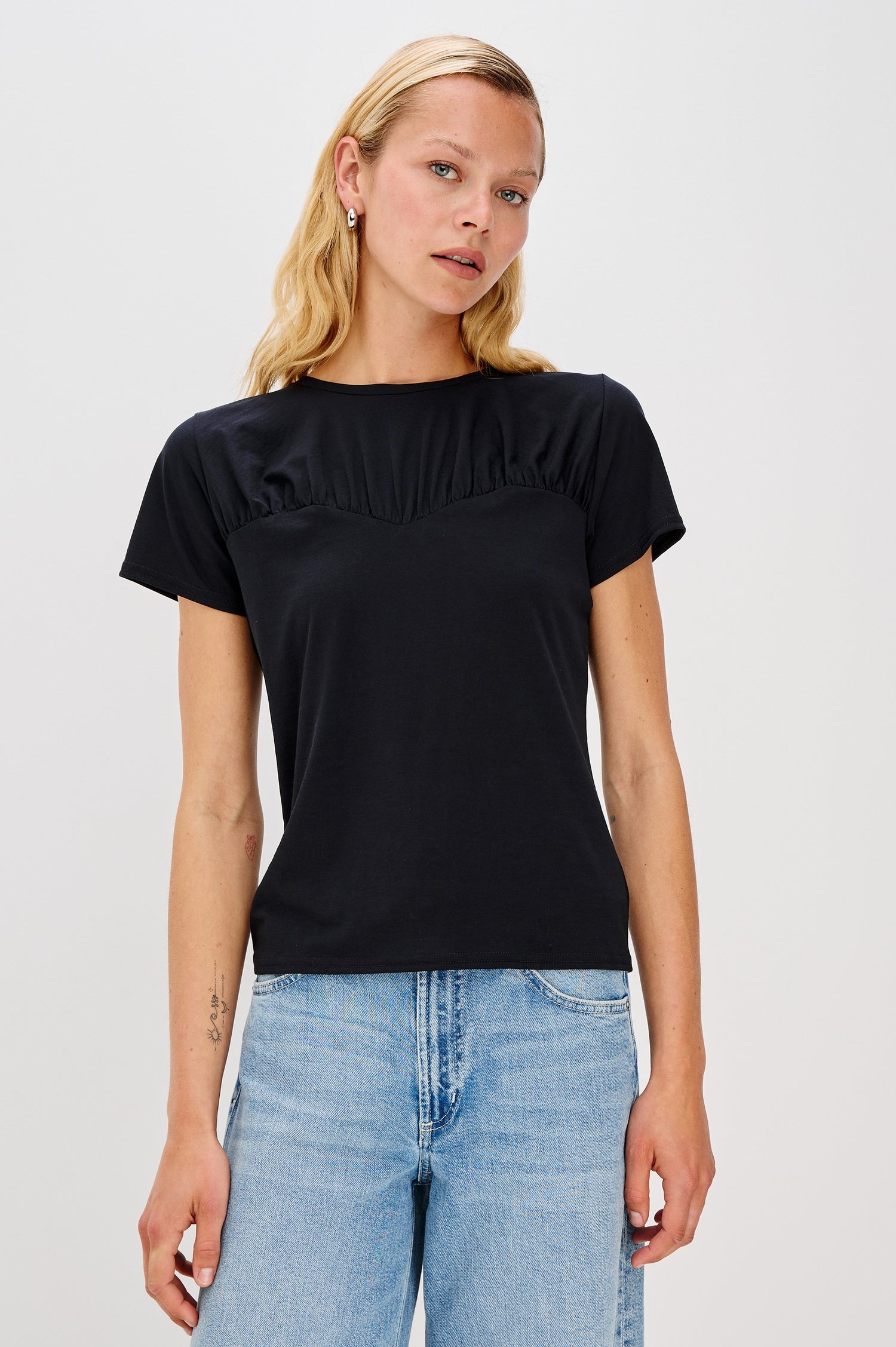 Janis crewneck short sleeve t-shirt with sweetheart neckline hem details in Black colorway - front view on model, untucked