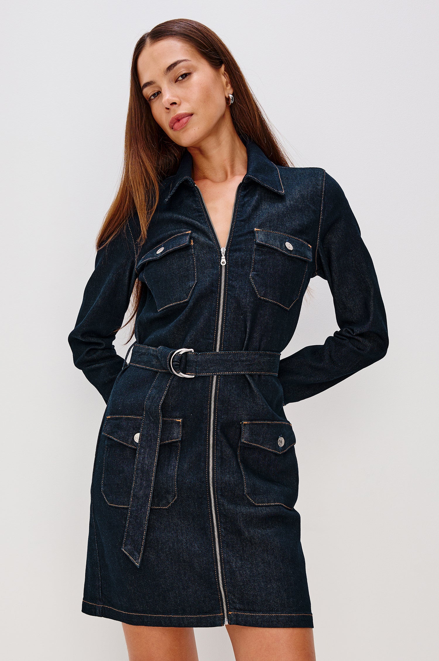 Jefferson Mini Dress in Denim With Long Sleeves, Collar, Zip Front, Buttoned Chest and Side Flap Pockets, and Adjustable D-Ring Waist Belt in Midnight Blue Colorway - Upper Body Front View Featured on Model
