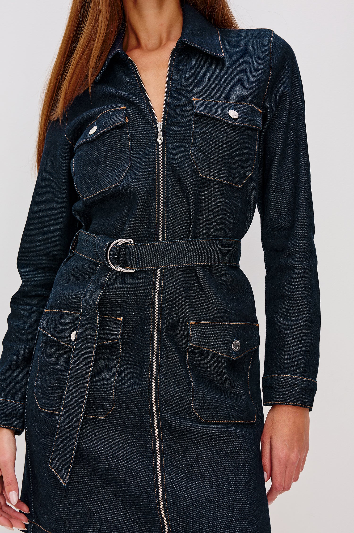 Jefferson Mini Dress in Denim With Long Sleeves, Collar, Zip Front, Buttoned Chest and Side Flap Pockets, and Adjustable D-Ring Waist Belt in Midnight Blue Colorway - Upper Body Front Close Up View Featured on Model