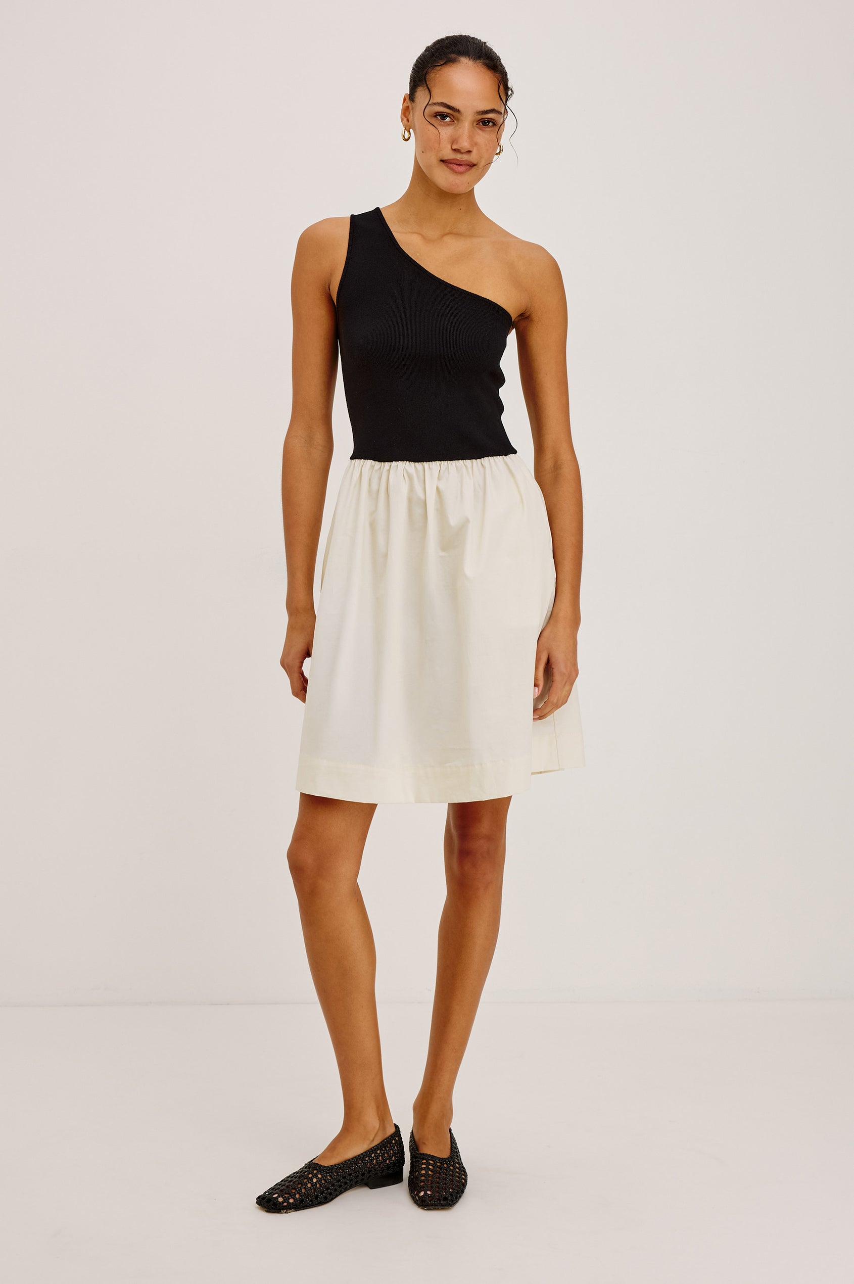 Joanne Mini Dress With One-Shoulder Neckline, Soft Jersey Bodice, Contrast Dropwaist Cotton Poplin Skirt, and Side Pockets in Black Ivory Colorway - Full Body Front View Featured on Model