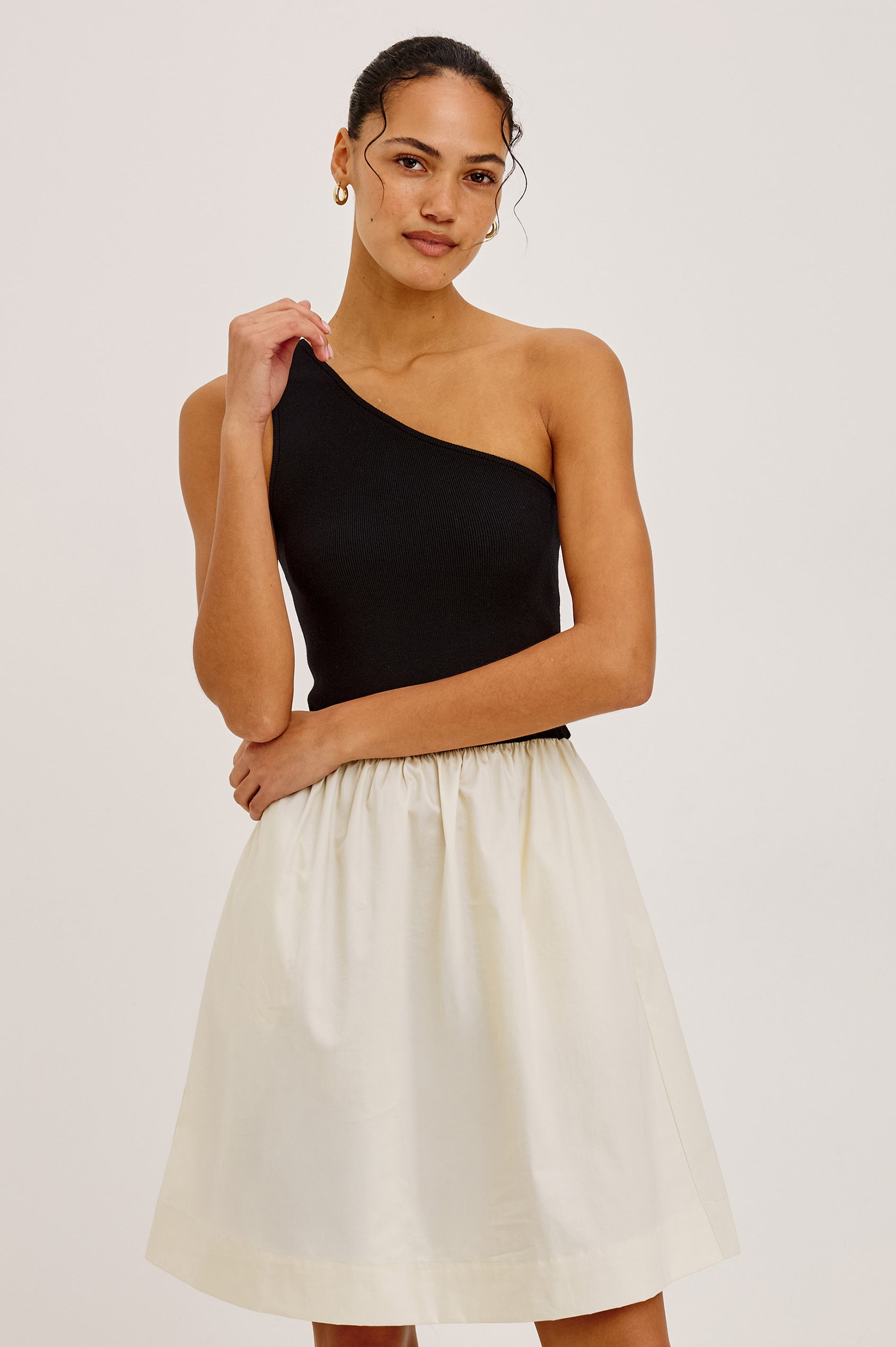 Joanne Mini Dress With One-Shoulder Neckline, Soft Jersey Bodice, Contrast Dropwaist Cotton Poplin Skirt, and Side Pockets in Black Ivory Colorway - Upper Body Front View Featured on Model