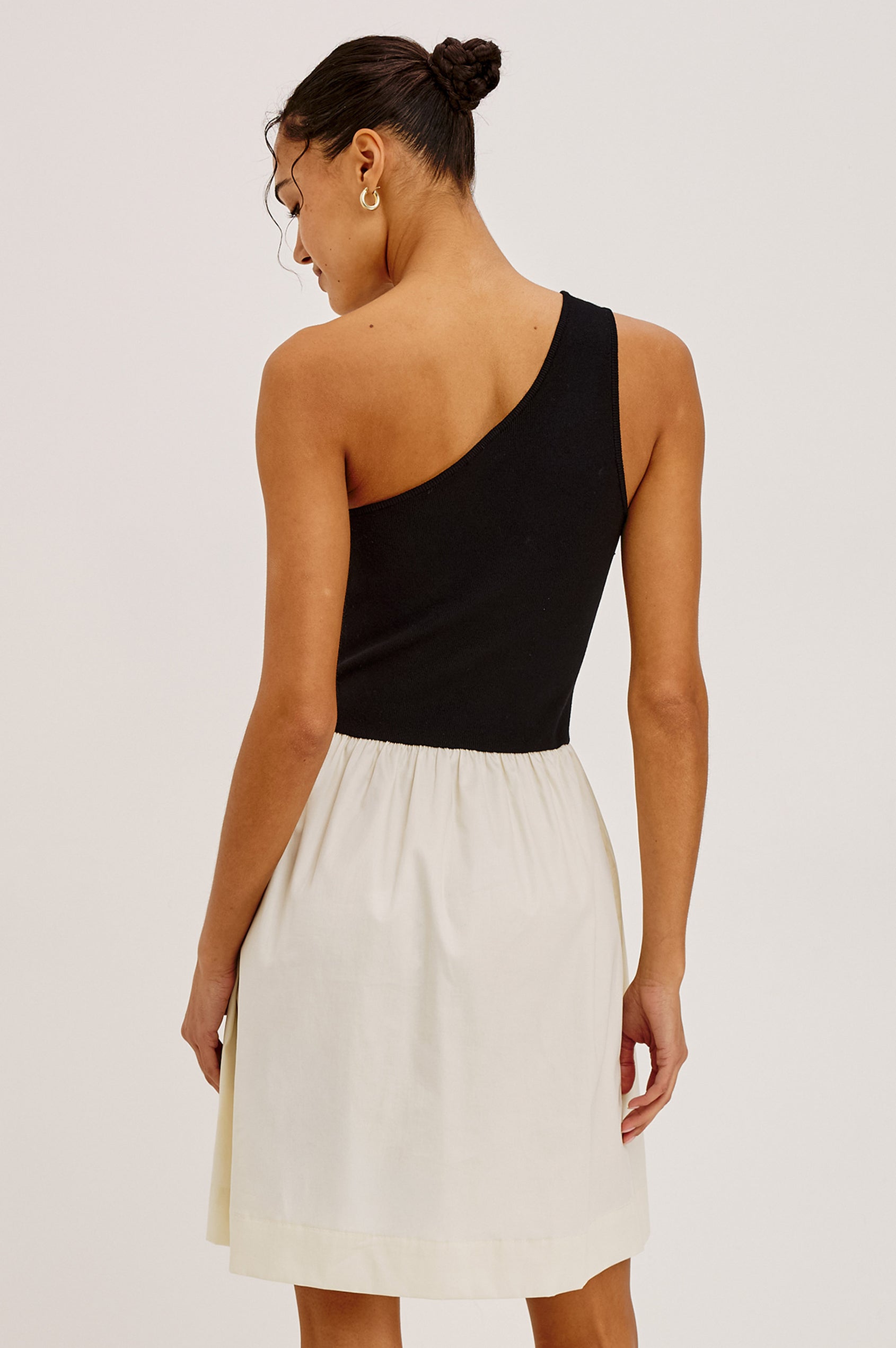 Joanne Mini Dress With One-Shoulder Neckline, Soft Jersey Bodice, Contrast Dropwaist Cotton Poplin Skirt, and Side Pockets in Black Ivory Colorway - Upper Body Back View Featured on Model