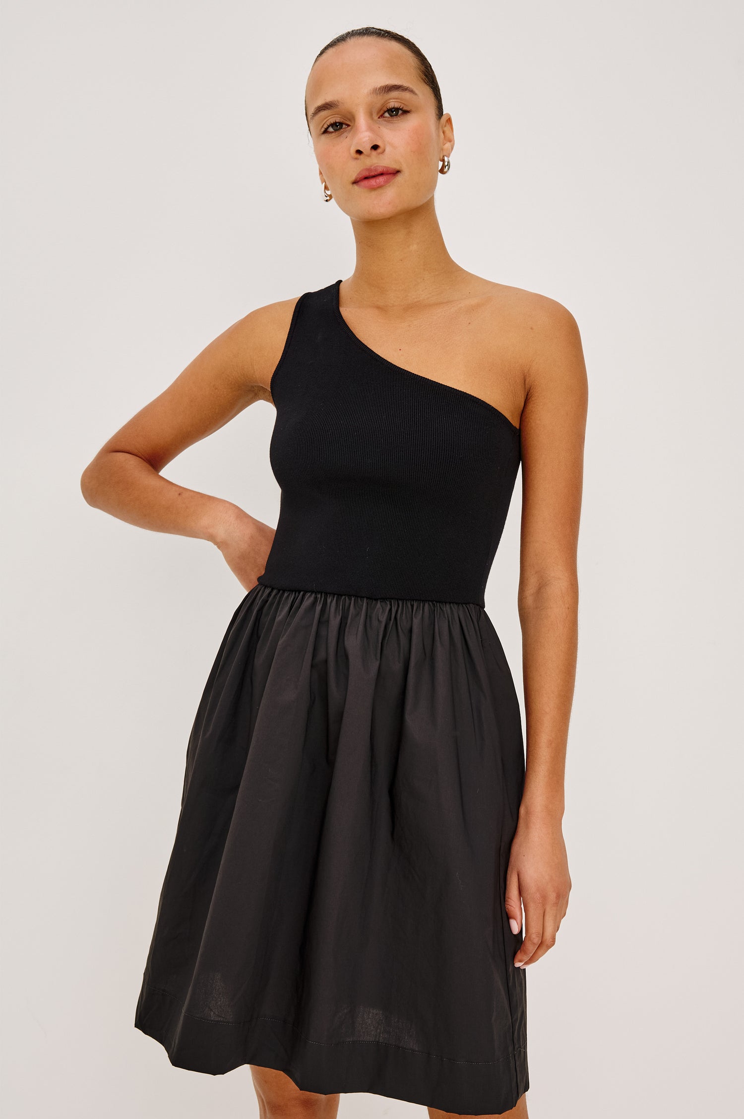 Joanne Mini Dress With One-Shoulder Neckline, Soft Jersey Bodice, Dropwaist Cotton Poplin Skirt, and Side Pockets in Black Colorway - Upper Body Front View Featured on Model
