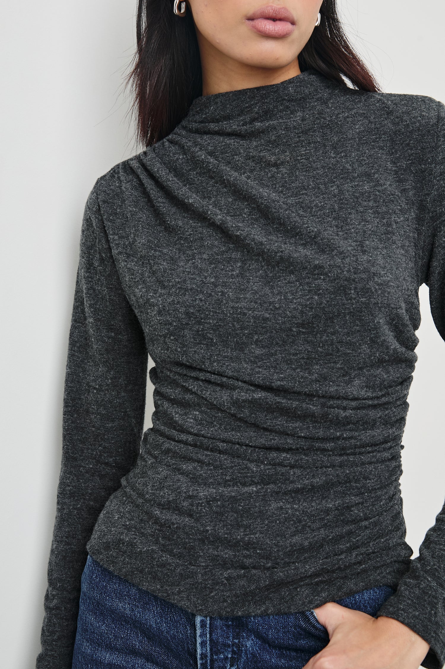 Joelle Long Sleeve Top with An Asymmetrical Mock Neck and Shirring on the Right Shoulder in Charcoal Colorway - Front View Featured on Model