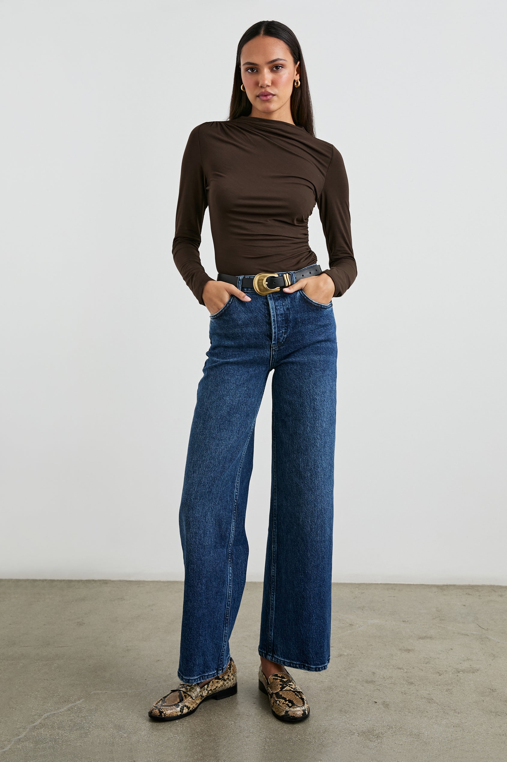 Joelle Long Sleeve Top with An Asymmetrical Mock Neck and Shirring on the Right Shoulder in Espresso Colorway - Front Tucked Full Body View Featured on Model