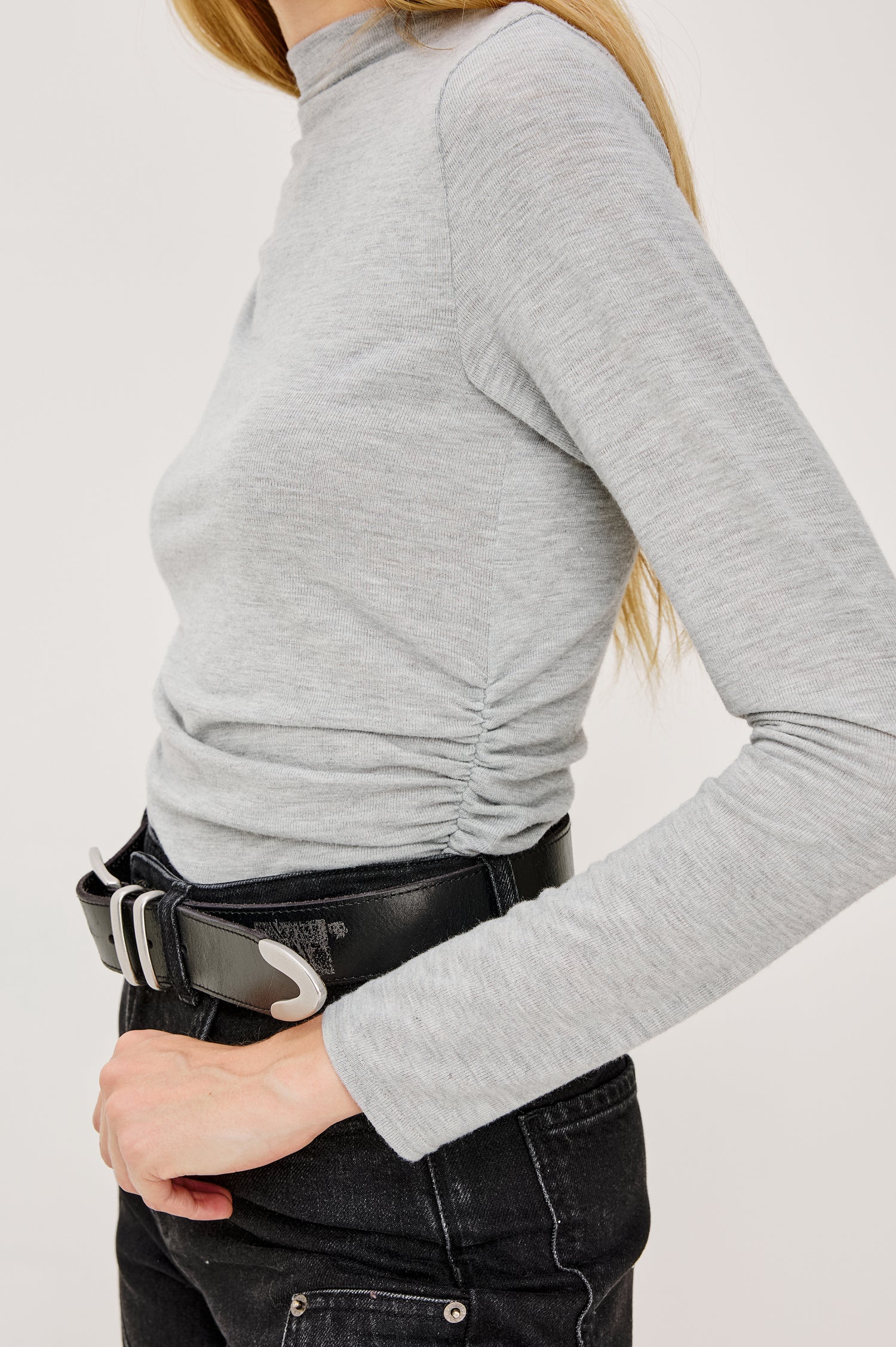 Joelle Top in Brushed Rib Jersey With Subtle Mock Neck, Fitted Silhouette, Side Shirring, and Long Sleeves in Heater Grey Colorway - Mid Body Side View Featued on Model