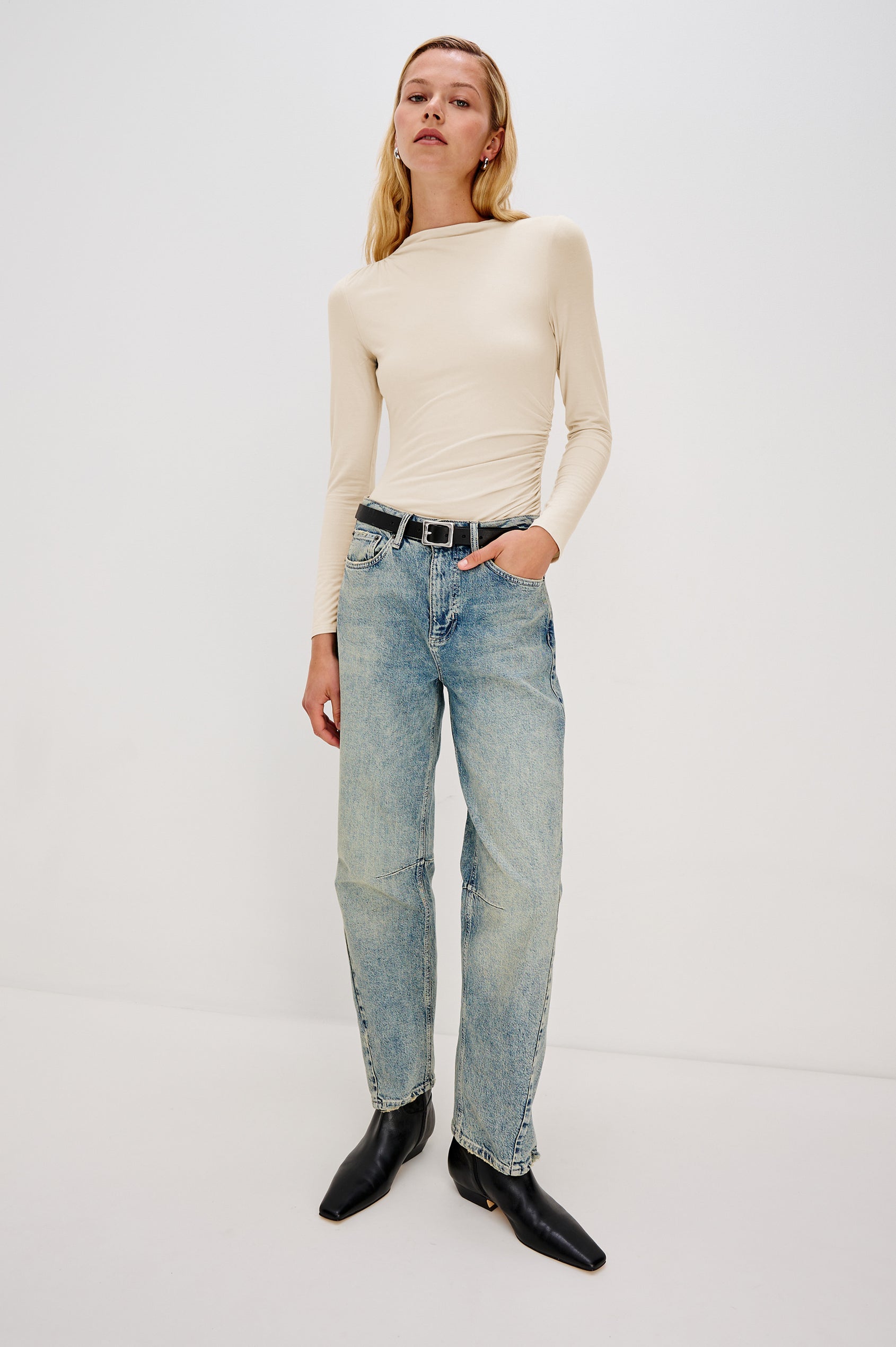 Joelle Long Sleeve Top with An Asymmetrical Mock Neck and Shirring on the Right Shoulder in Ivory Colorway - Full Body Front View Featured on Model