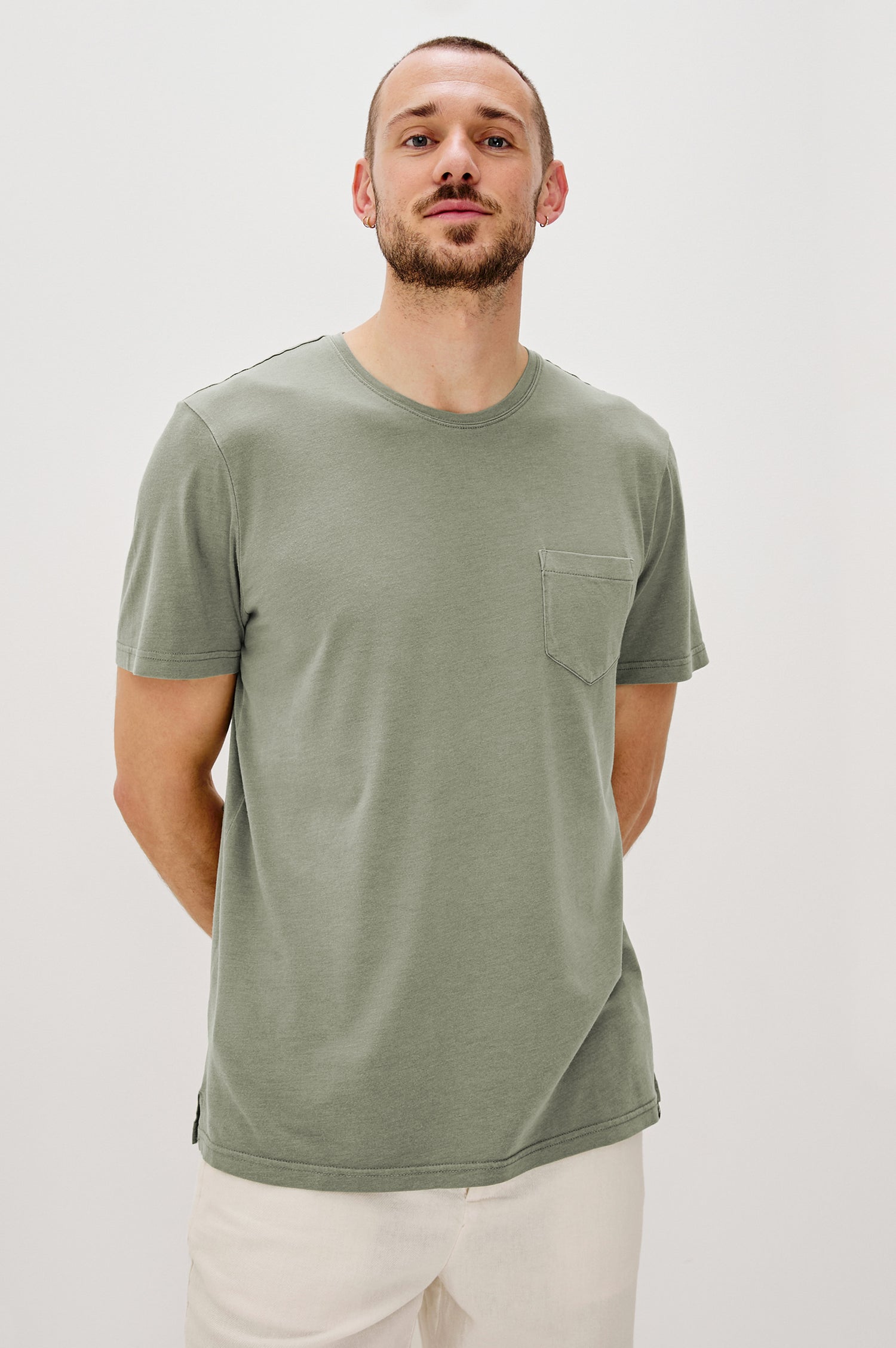 Johnny Short Sleeve T-Shirt with a Crew Neck, Chest Patch Pocket and Small Slits at the Side Hems in Olive Colorway - Front View Featured on Model