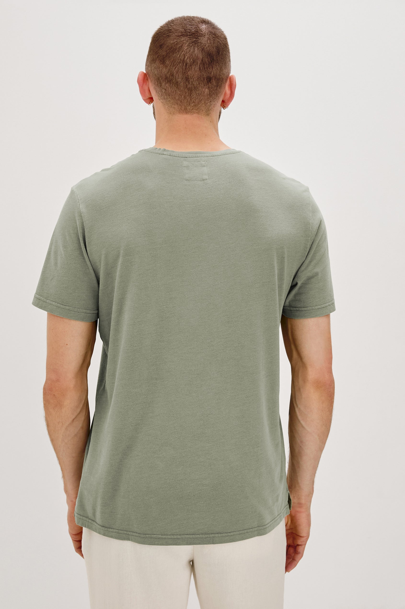 Johnny Short Sleeve T-Shirt with a Crew Neck, Chest Patch Pocket and Small Slits at the Side Hems in Olive Colorway - Back View Featured on Model