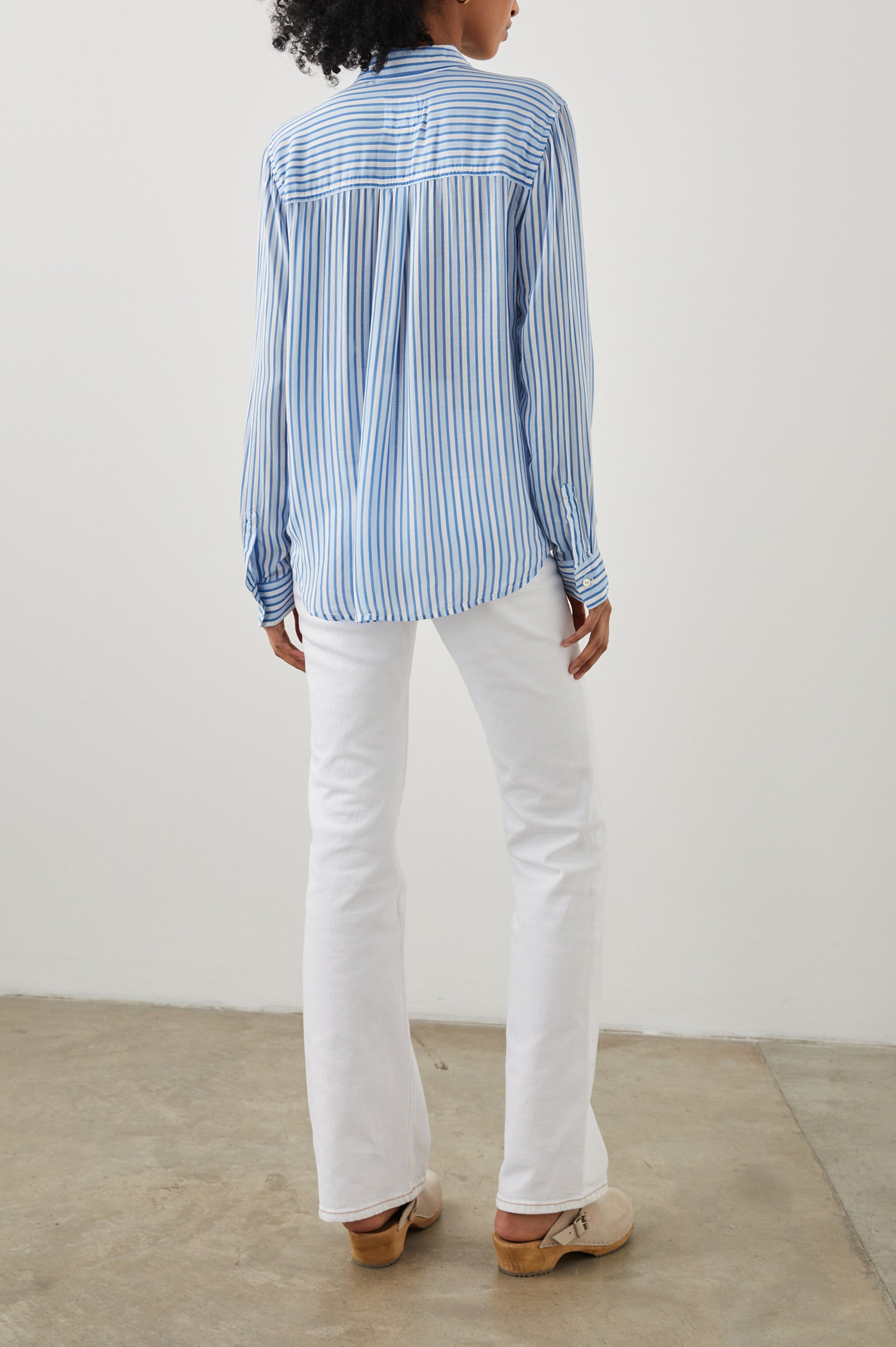 Josephine Long-Sleeve Button Down with a Chest Patch Pocket in Mar Stripe Colorway, vertical stripes in white and blues - Back View Featured on Model