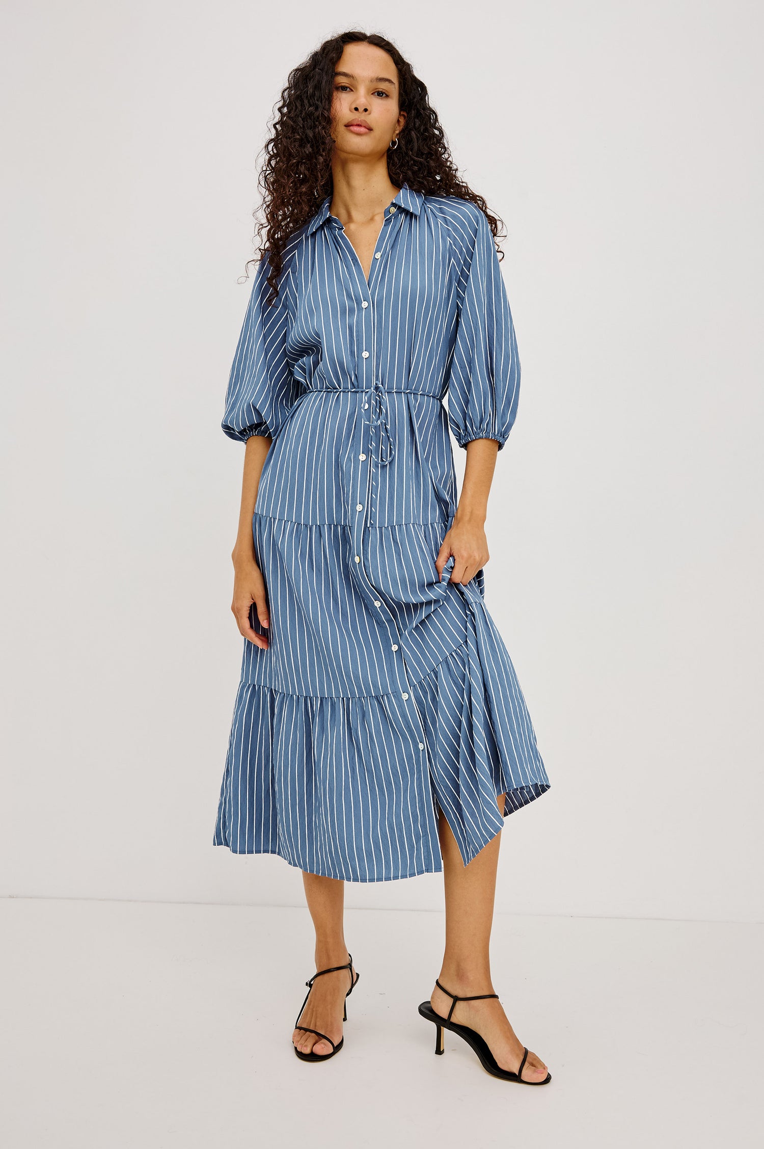 June Maxi Dress in Soft Crinkle Shirting With Three-Quarter Puff Sleeves, Point Collar, Full Front Button Placket, and Self-Tie Waist in Washed Indigo Stripe Colorway - Full Body Front View Featured on Model