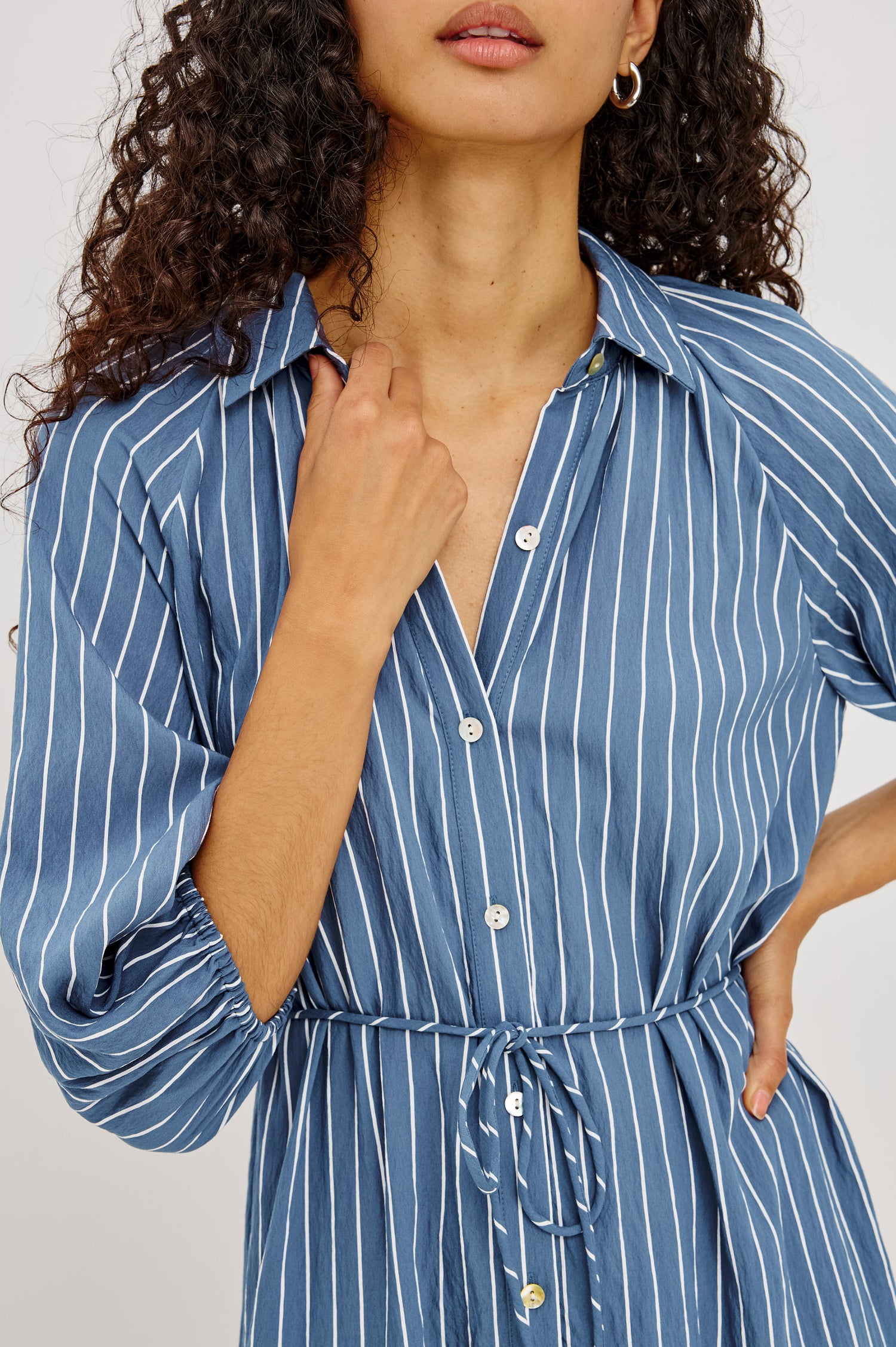 June Maxi Dress in Soft Crinkle Shirting With Three-Quarter Puff Sleeves, Point Collar, Full Front Button Placket, and Self-Tie Waist in Washed Indigo Stripe Colorway - Upper Body Front View Featured on Model