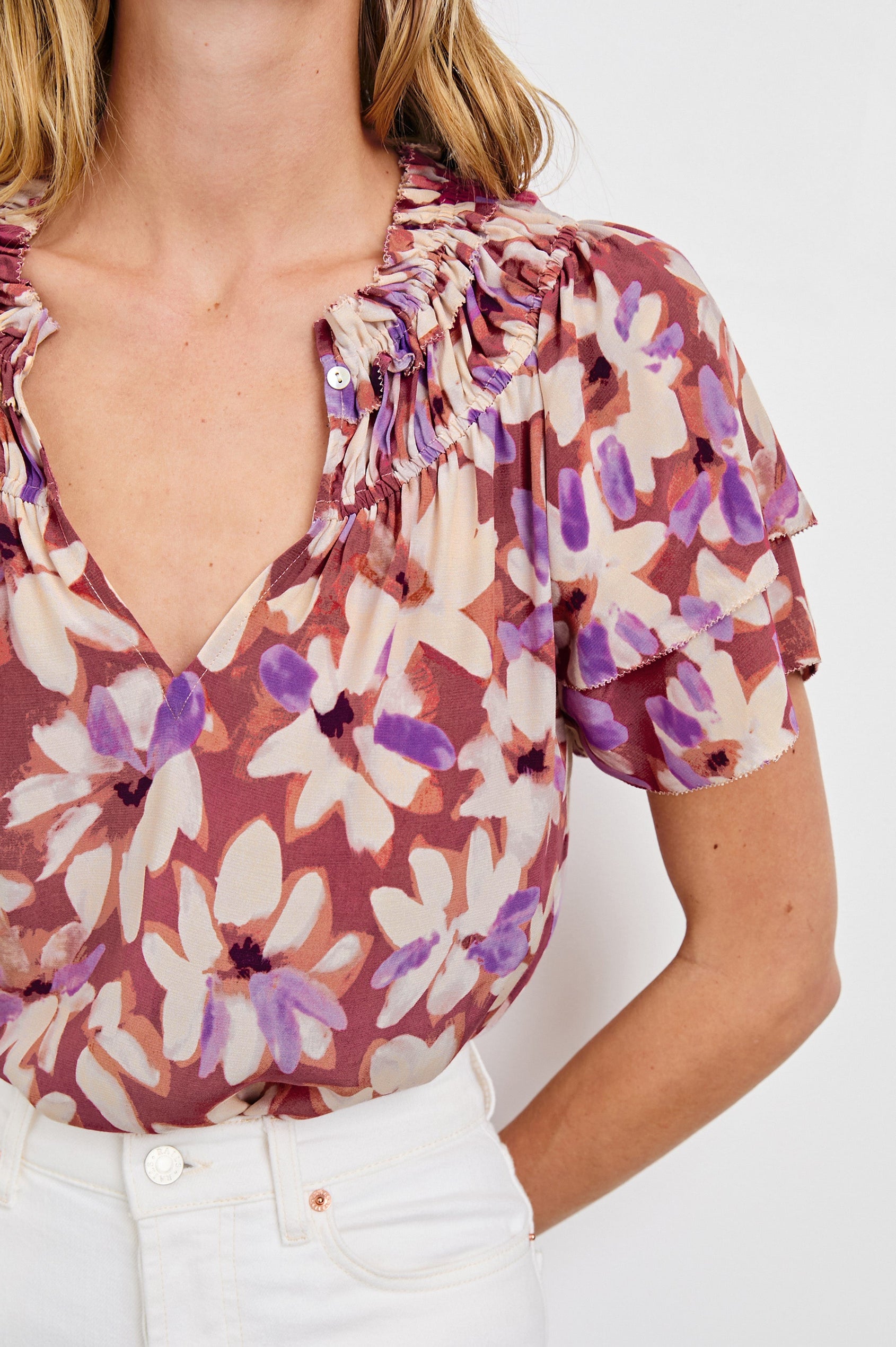 Kamila loose fit short sleeve shirt with a v neckline, ruffled collar, and flutter sleeves in Amaranth Colorway - close up of details on model