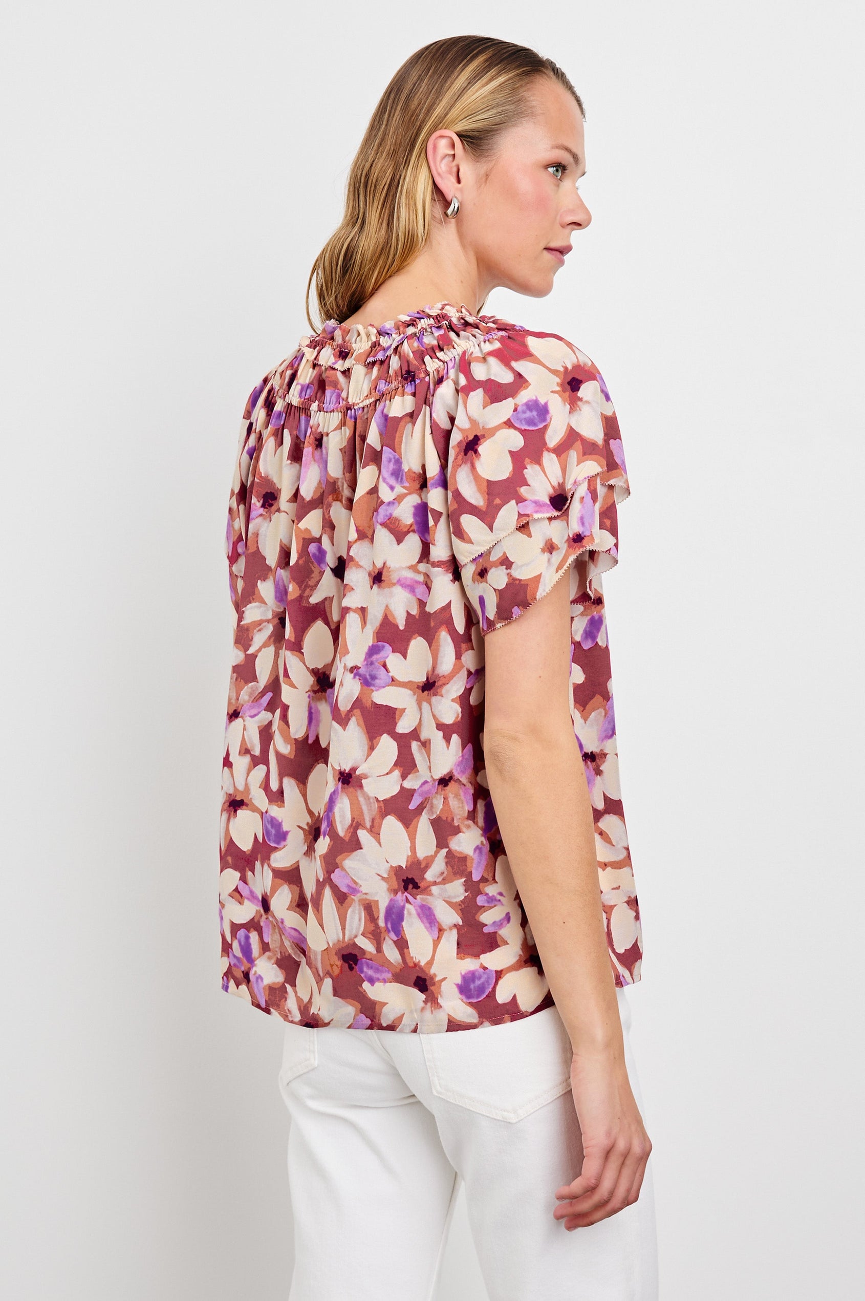 Kamila loose fit short sleeve shirt with a v neckline, ruffled collar, and flutter sleeves in Amaranth Colorway - back view on model