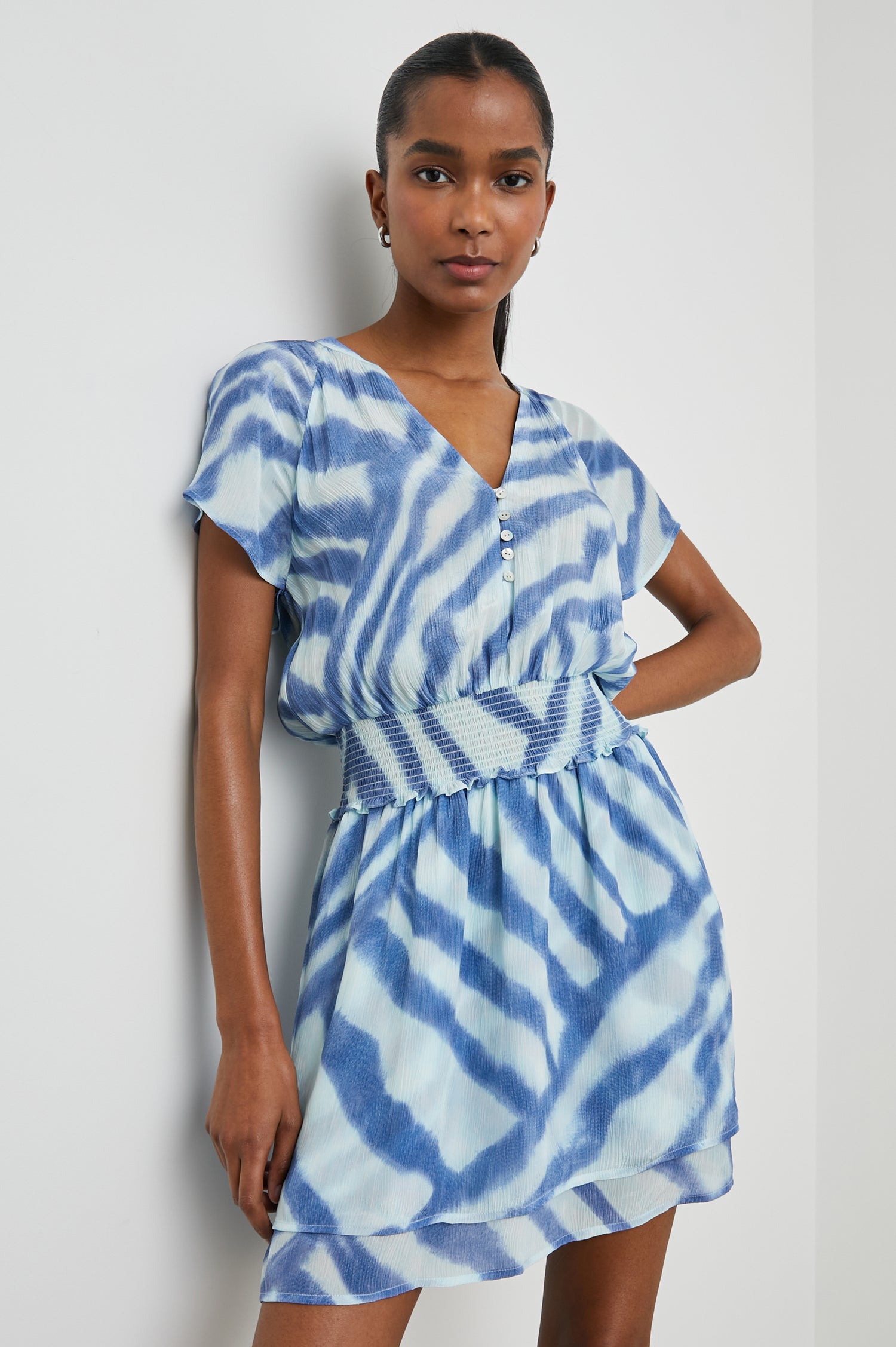 Karla Short Sleeve Mini Dress with a V Neck with Four Buttons, a Shirred Waist and a Double-Layered Skirt in Blue Watercolor Stripes Colorway, Blue on Light Blue - Front View Featured on Model