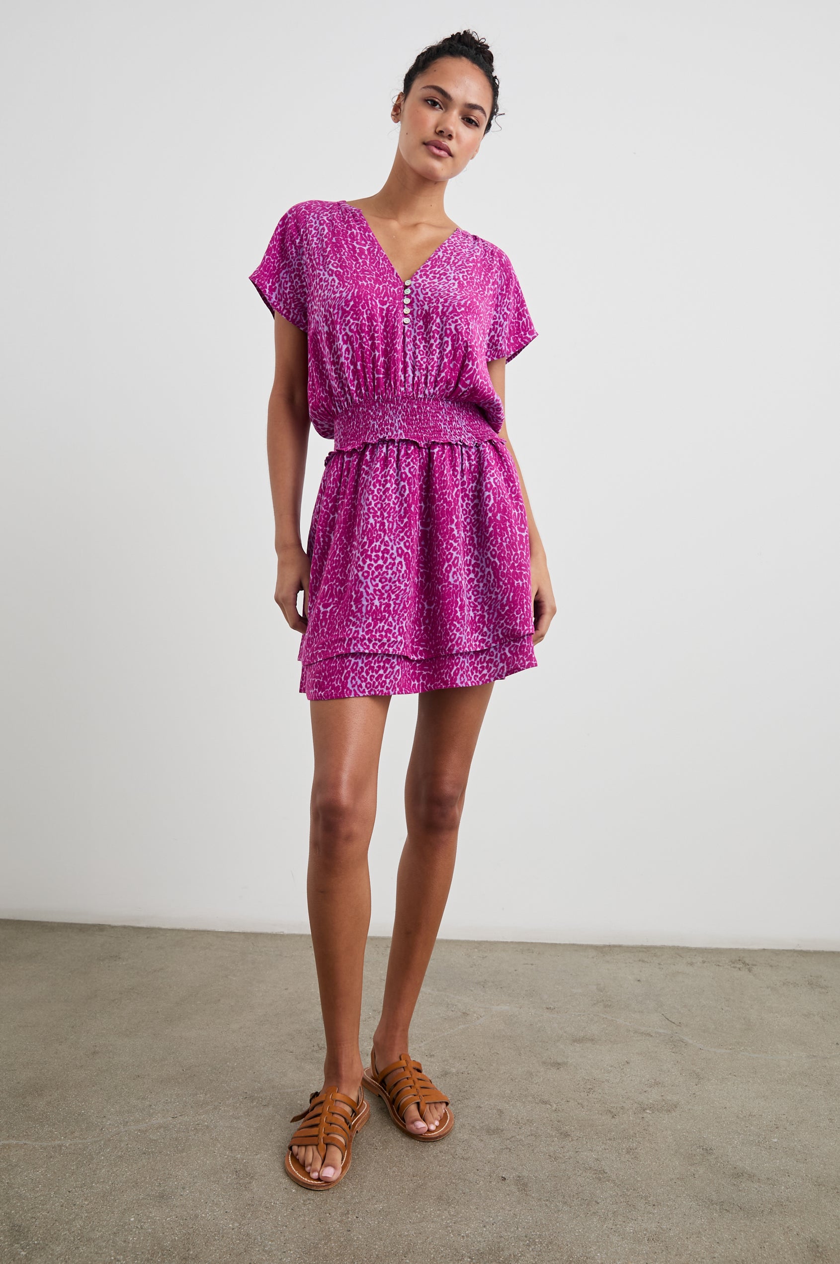 Karla Short Sleeve Mini Dress with a V Neck with Four Buttons, a Shirred Waist and a Double-Layered Skirt in Magenta Cheetah Colorway, Magenta Spots on White - Front Full Body View Featured on Model