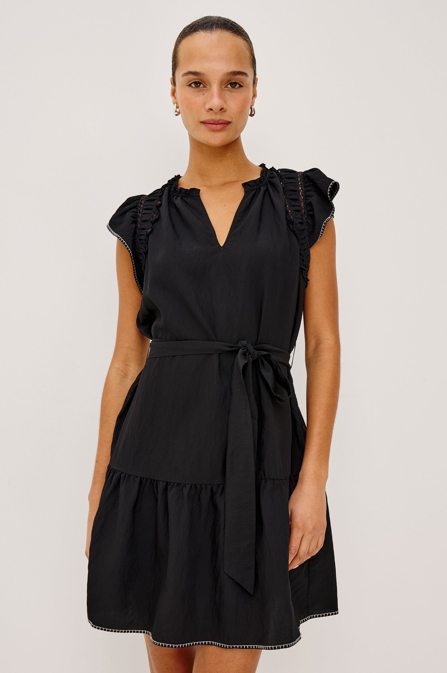 Katia Mini Dress in Textured Poplin With Shirring, Lace, and Ruffle Trim at Shoulders, Flutter Sleeves With Contrast Stitching, Adjustable Belted Ties, and Fully Lined Skirt in Black Colorway - Upper Body Front View Featured on Model
