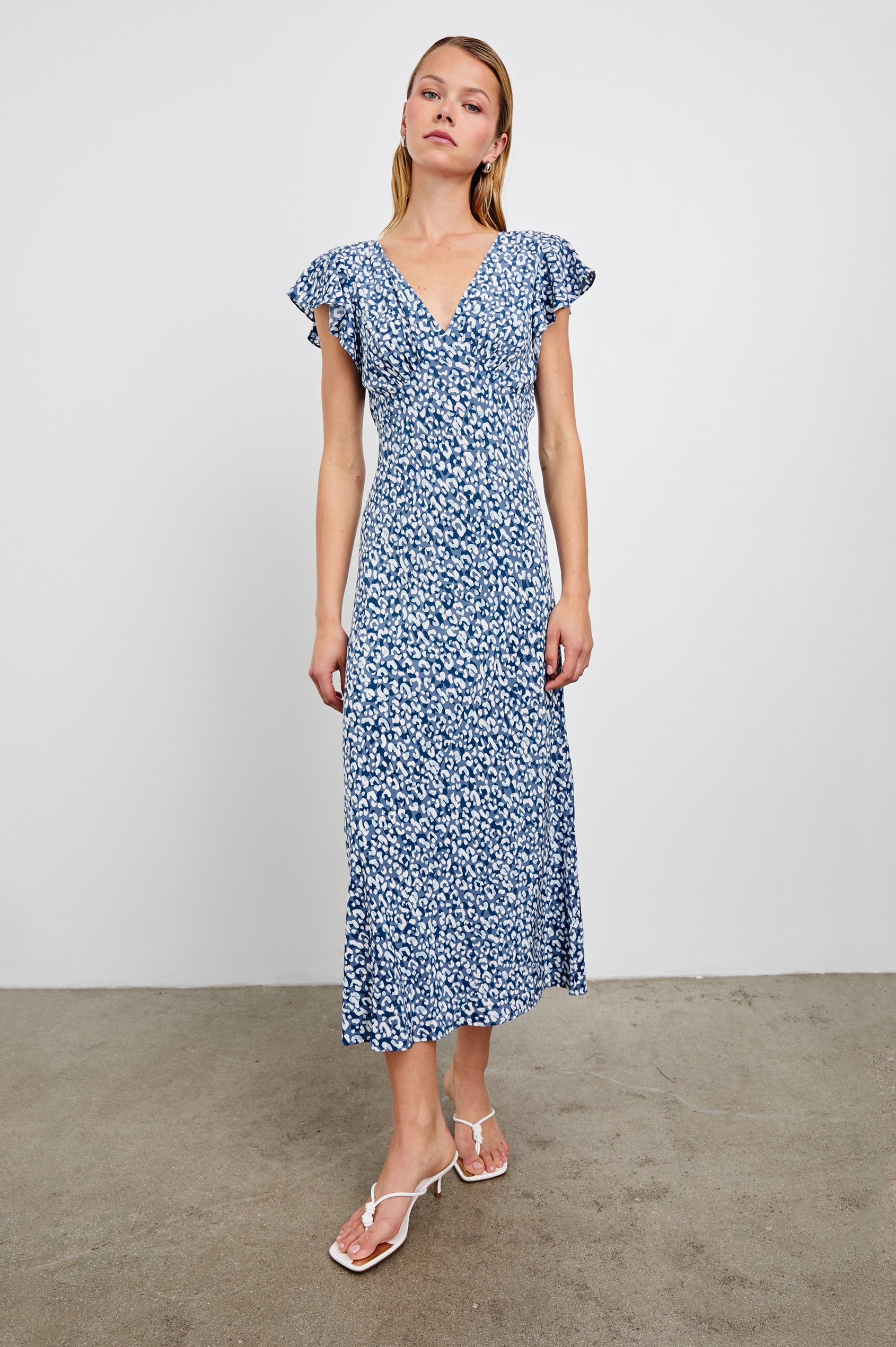 Kenz Midi Dress with Flutter cap Sleeves, and a deep V Neck in Blue Mixed Cheetah Colorway, Spots in Blues and White - Front Full Body View Featured on Model