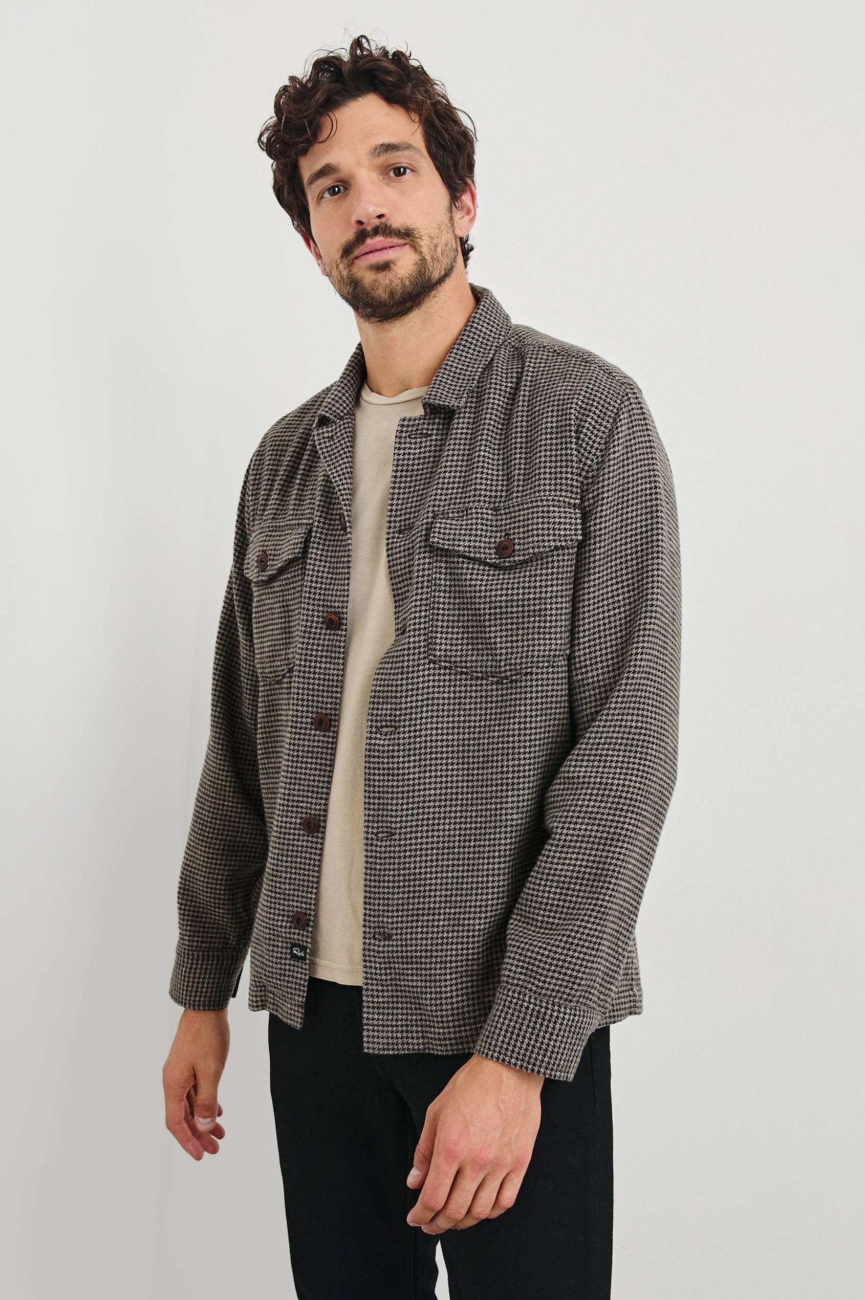 Kerouac Long-Sleeve Shirt Jacket with Button Closure and Two Button Chest Flap Pockets in Mire Colorway, a Tan and Black Houndstooth - Front Unbuttoned View Featured on Model