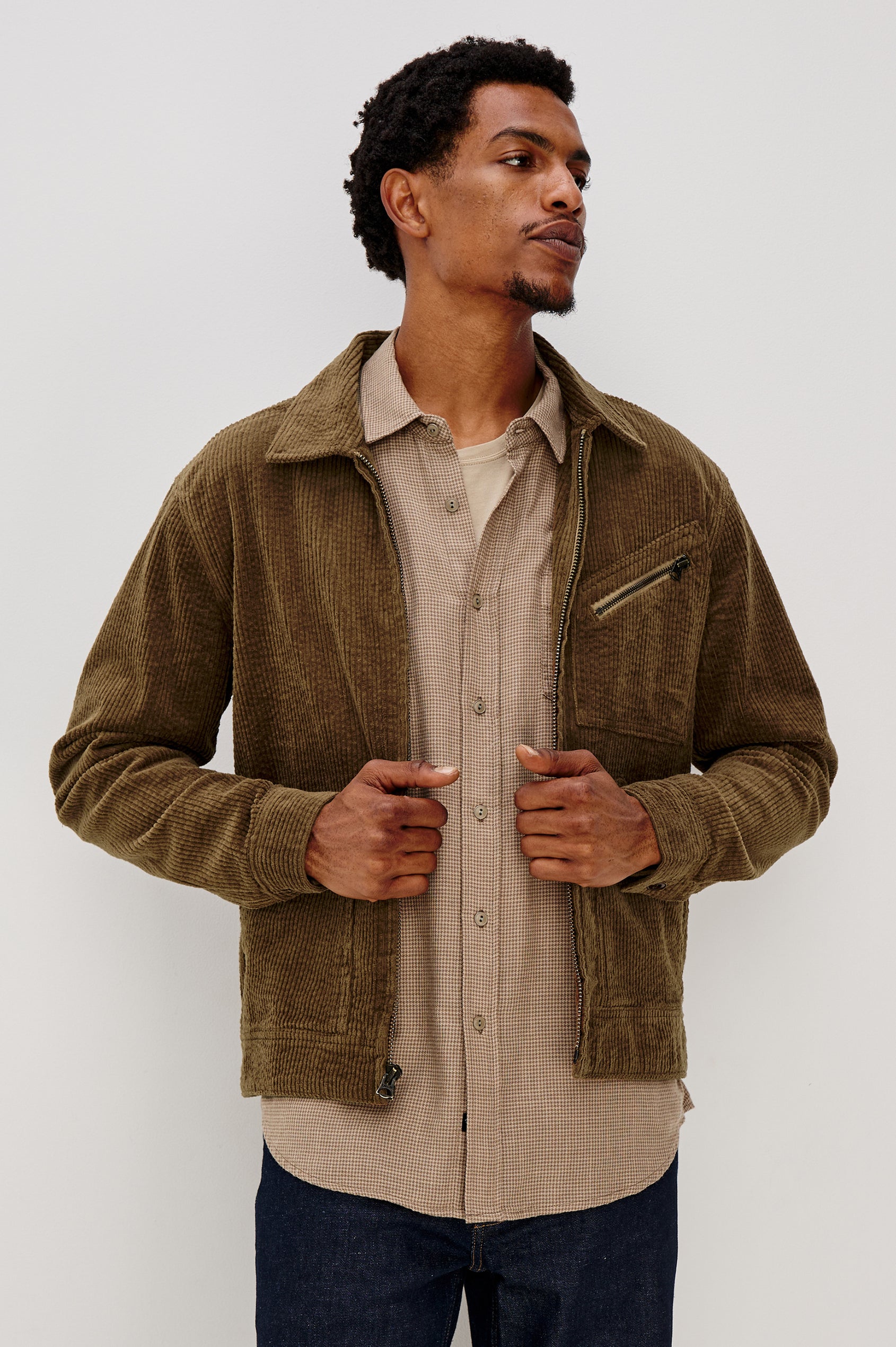 Ketter Zip Up Jacket with Two Curved Front Patch Pockets, a Diagonally Zippered Chest Patch Pocket and Adjustable Button Straps on the Hem in Chicory Colorway, a Warm Brown with Non Contrast Collar - Front View Featured on Model.