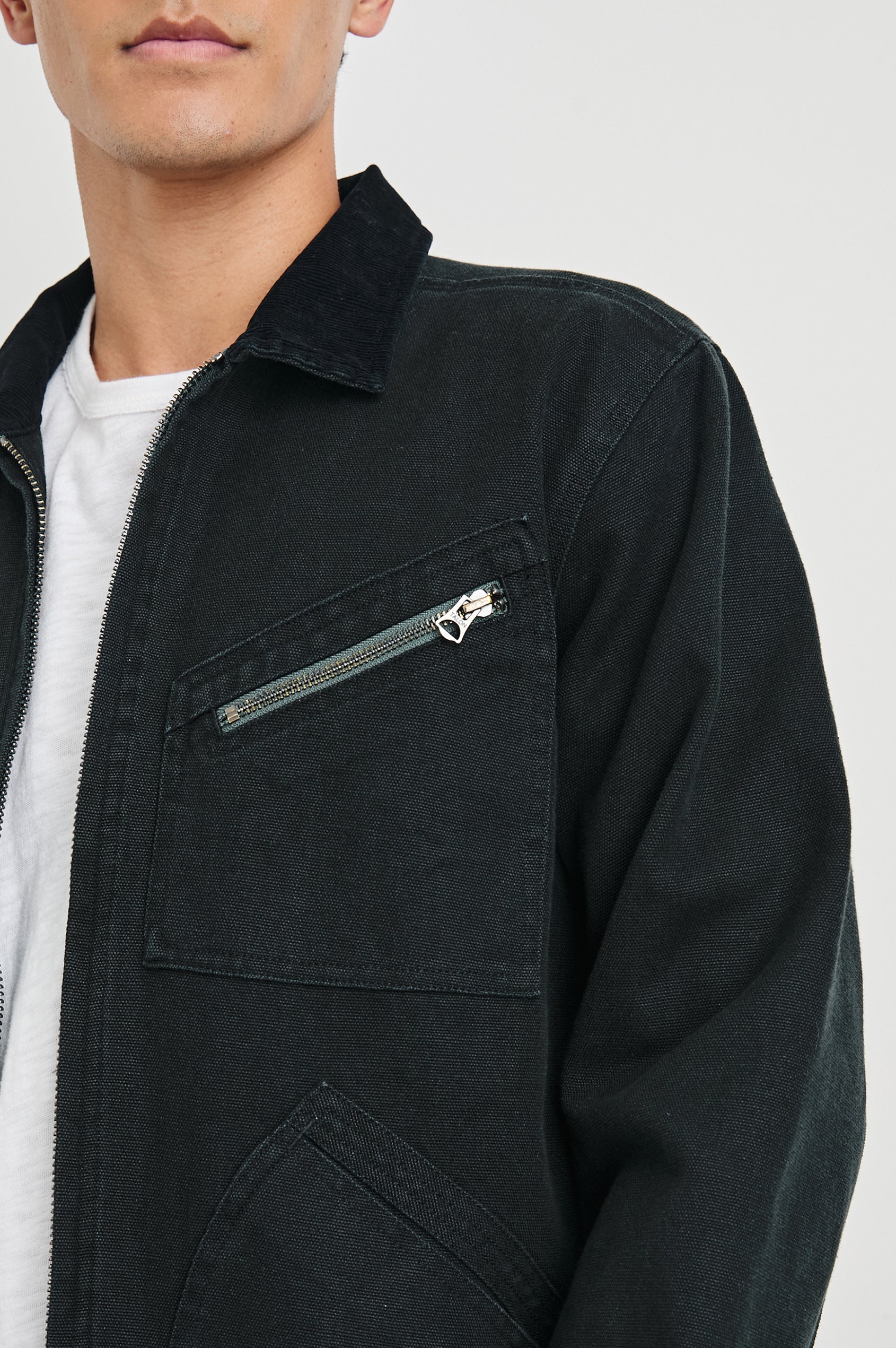 Ketter Zip Up Jacket with Two Curved Front Patch Pockets, a Diagonally Zippered Chest Patch Pocket and Adjustable Button Straps on the Hem in Raven Colorway - Front View Featured on Model