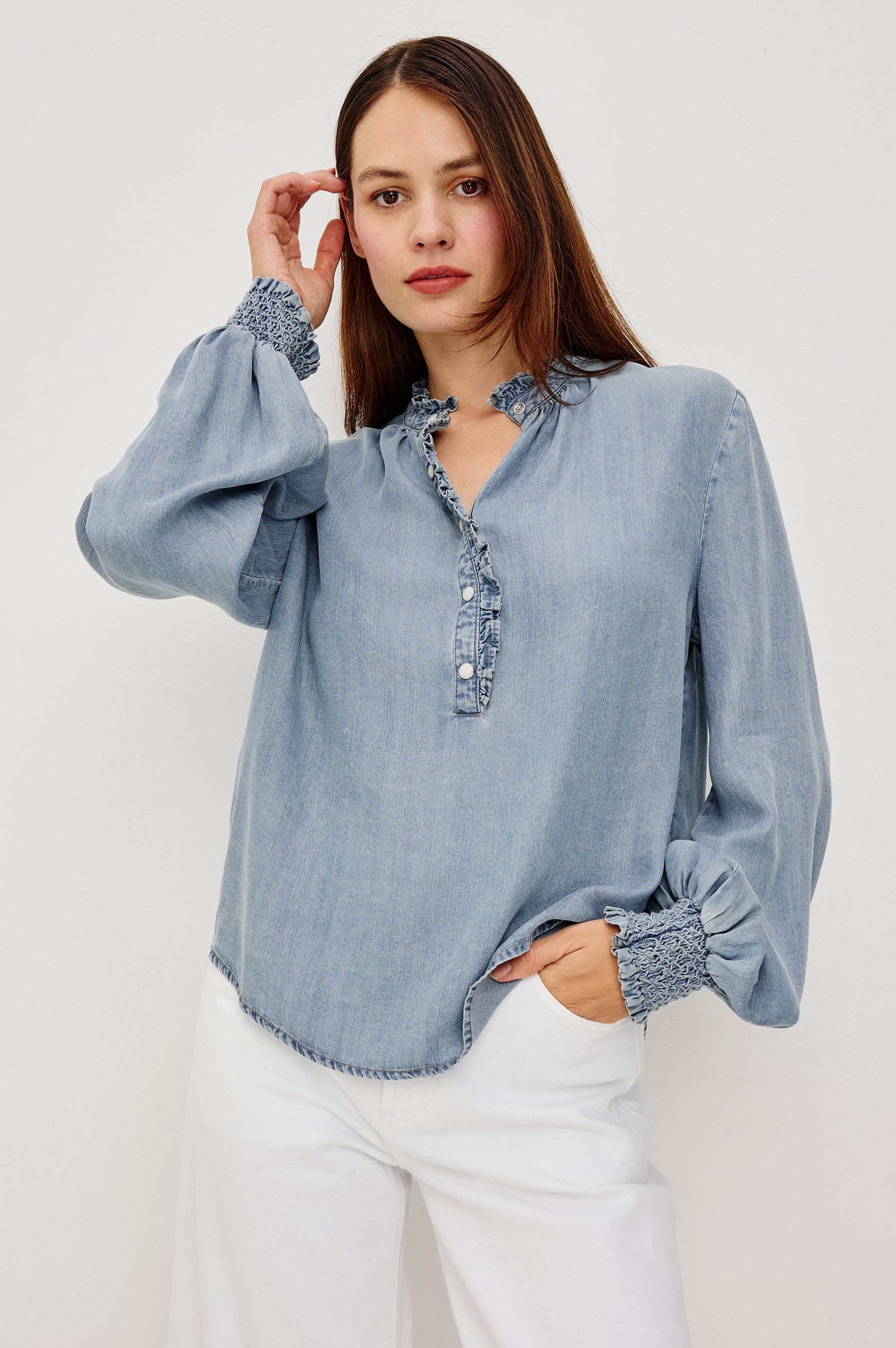 Kimmy TENCELâ„¢ Denim Top With Band Collar Half-Button Placket Long Gathered Sleeves With Smocked Cuffs and Loose Relaxed Fit in Washed Blue Colorway - Upper Body Front View Featured on Model