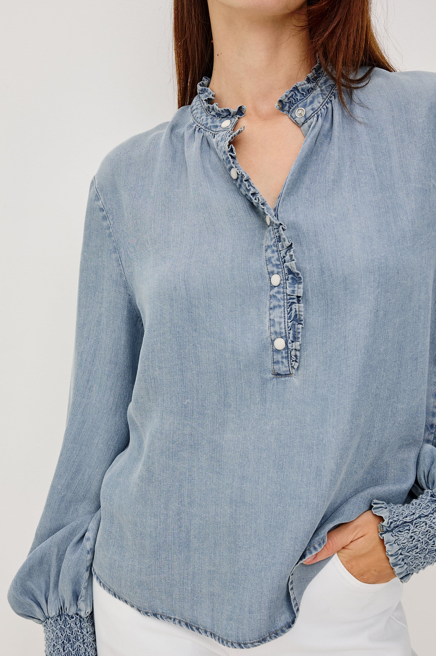 Kimmy TENCELâ„¢ Denim Top With Band Collar Half-Button Placket Long Gathered Sleeves With Smocked Cuffs and Loose Relaxed Fit in Washed Blue Colorway - Upper Body Close Up Front View Featured on Model