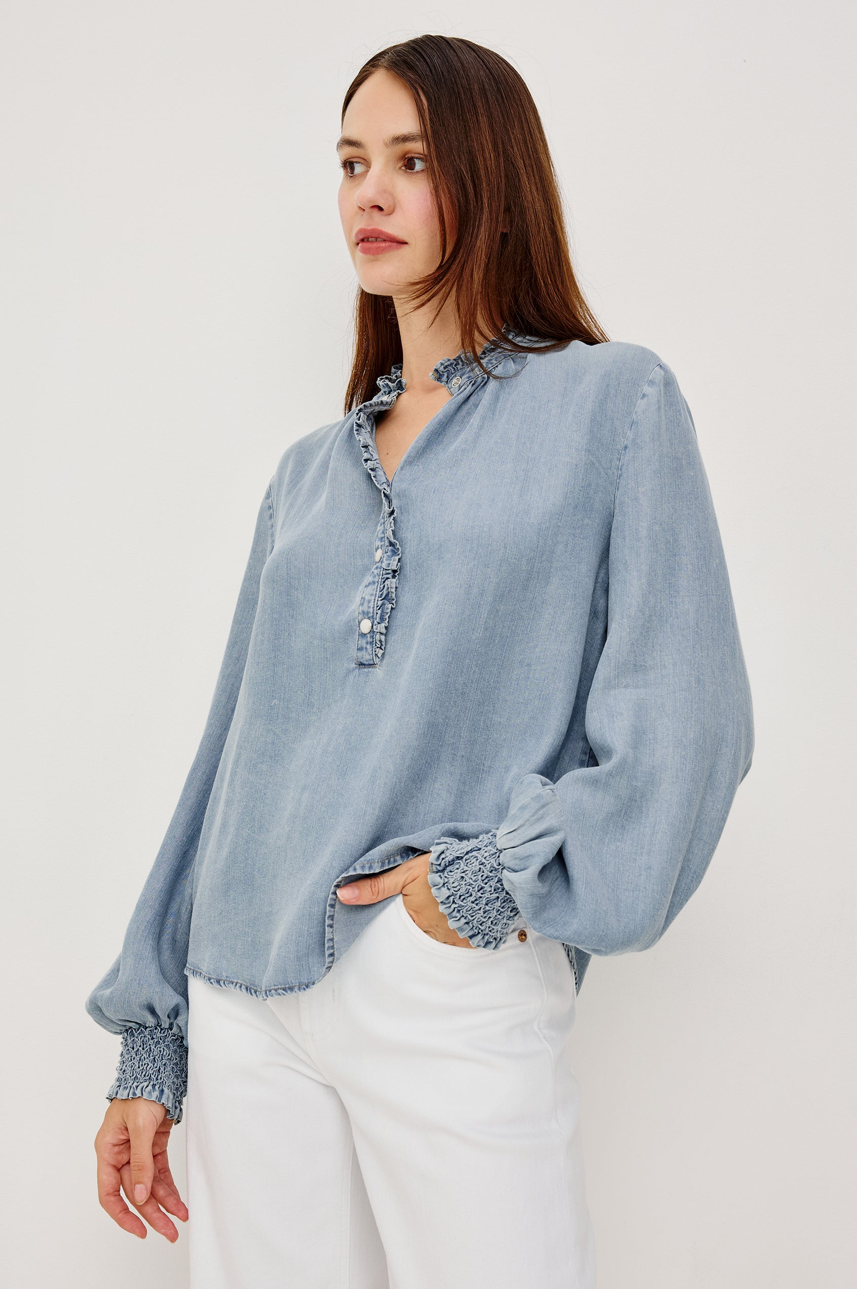 Kimmy TENCELâ„¢ Denim Top With Band Collar Half-Button Placket Long Gathered Sleeves With Smocked Cuffs and Loose Relaxed Fit in Washed Blue Colorway - Upper Body Front View Featured on Model