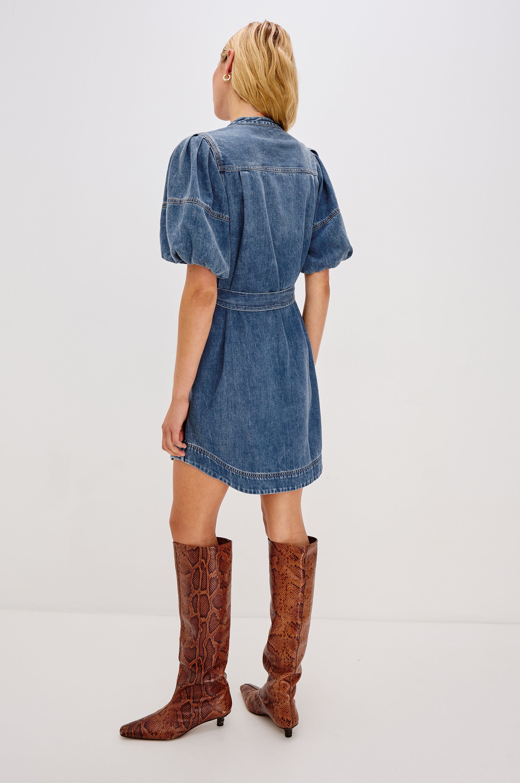 Kingsley Denim Mini Dress with Elbow-Length Puff Sleeves, a V Neck, Snaps Down the Front and a Fabric Tie Belt in Antique Blue Colorway - back view on model