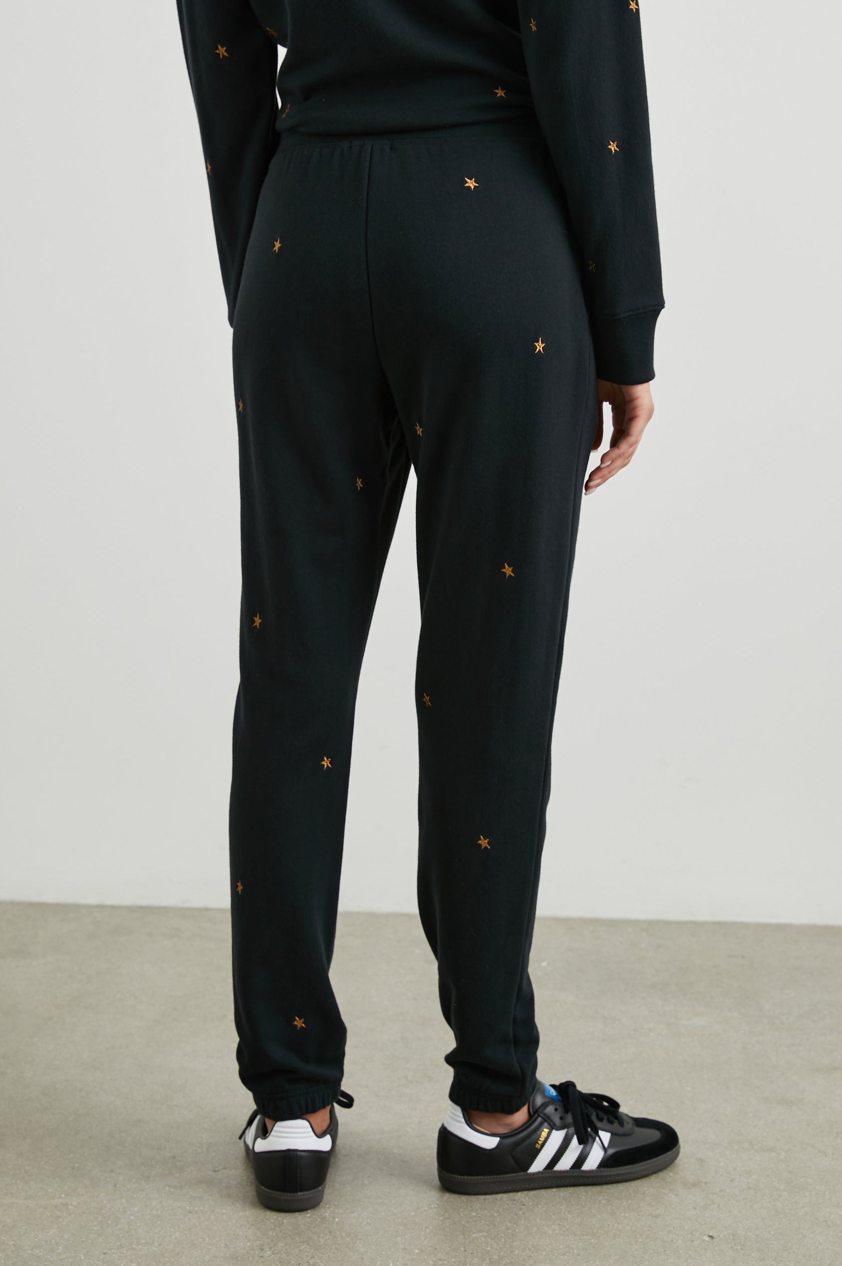 Kingston Sweatpants with Elastic Cuffs and Waist with Drawcord in Bronze Star Embroidery Colorway, Bronze Stars on Black - Back View Featured on Model
