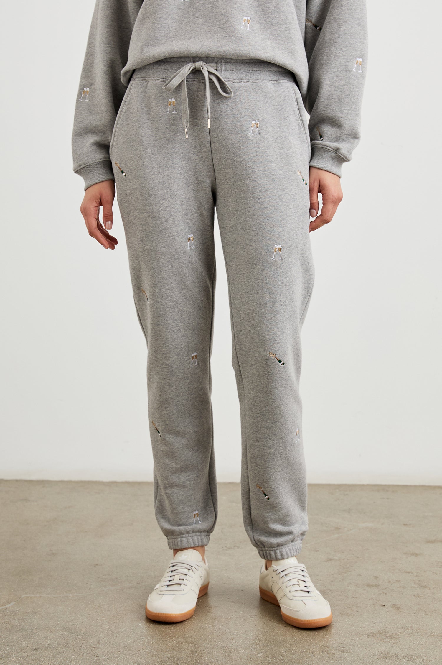 Kingston Pants with Elastic Cuffs and Waist with Drawcord in Champagne Embroidery Colorway, Champagne Glasses on Grey - Front View Featured on Model