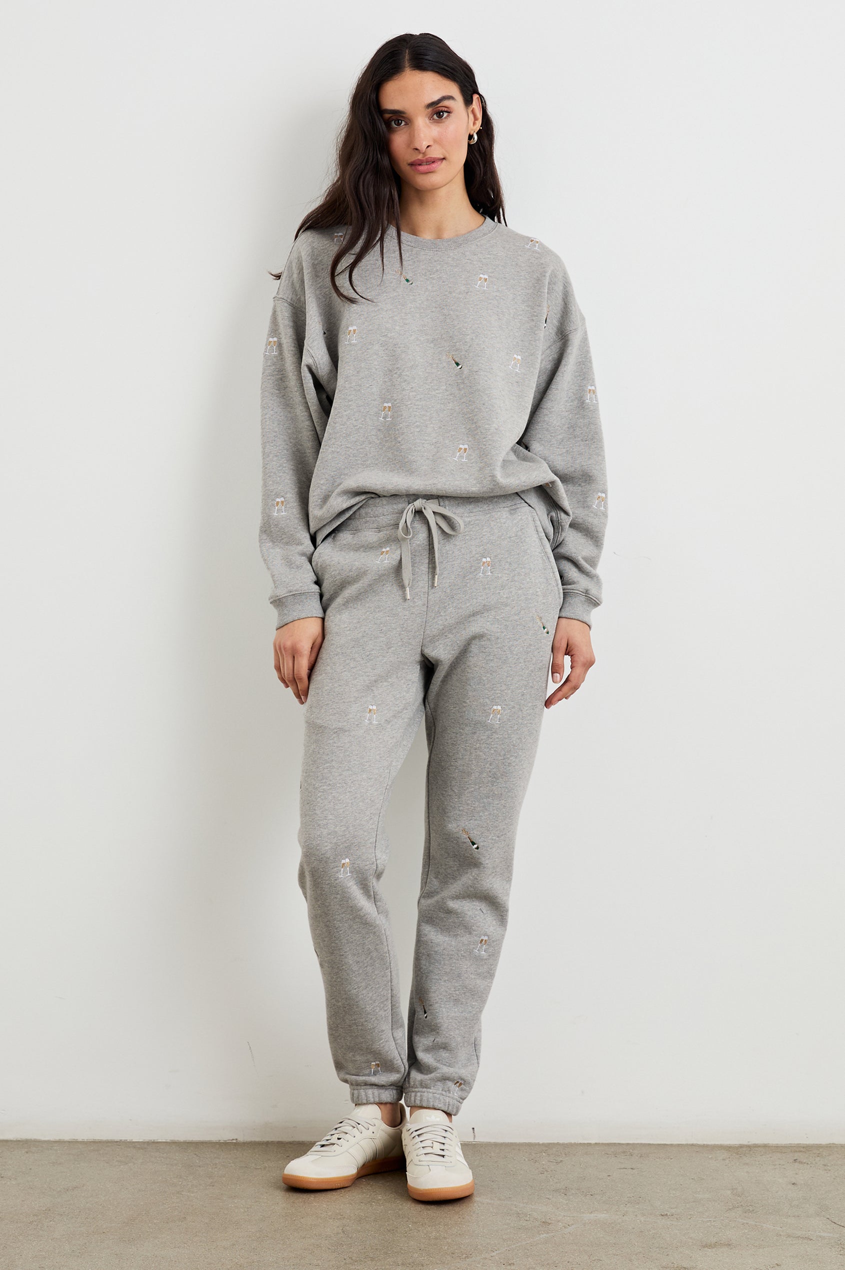 Kingston Pants with Elastic Cuffs and Waist with Drawcord in Champagne Embroidery Colorway, Champagne Glasses on Grey - Front Full Body View Featured on Model