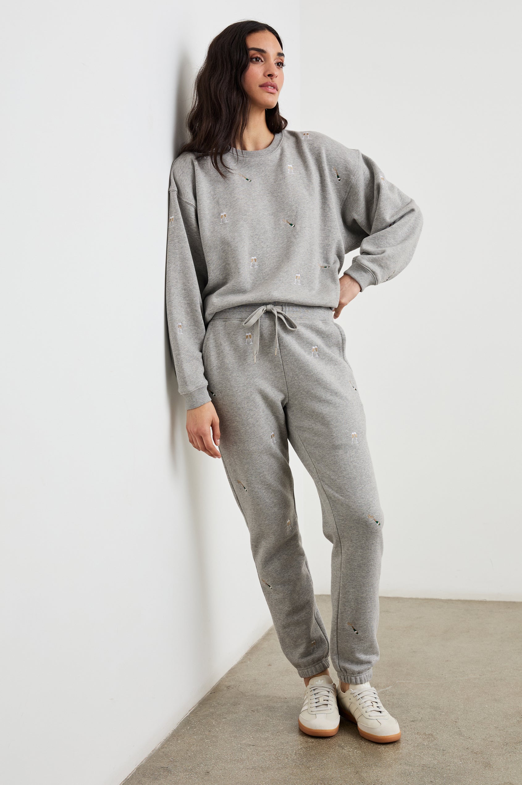 Kingston Pants with Elastic Cuffs and Waist with Drawcord in Champagne Embroidery Colorway, Champagne Glasses on Grey - Front Full Body View Featured on Model